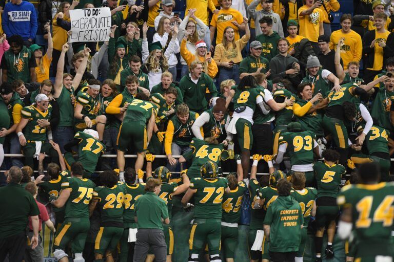 North Dakota State Bison football climbs into the student section to celebrate their win over South Dakota State Jackrabbits on Saturday, Dec. 21, 2024, at Fargodome in Fargo, Nouth Dakota.