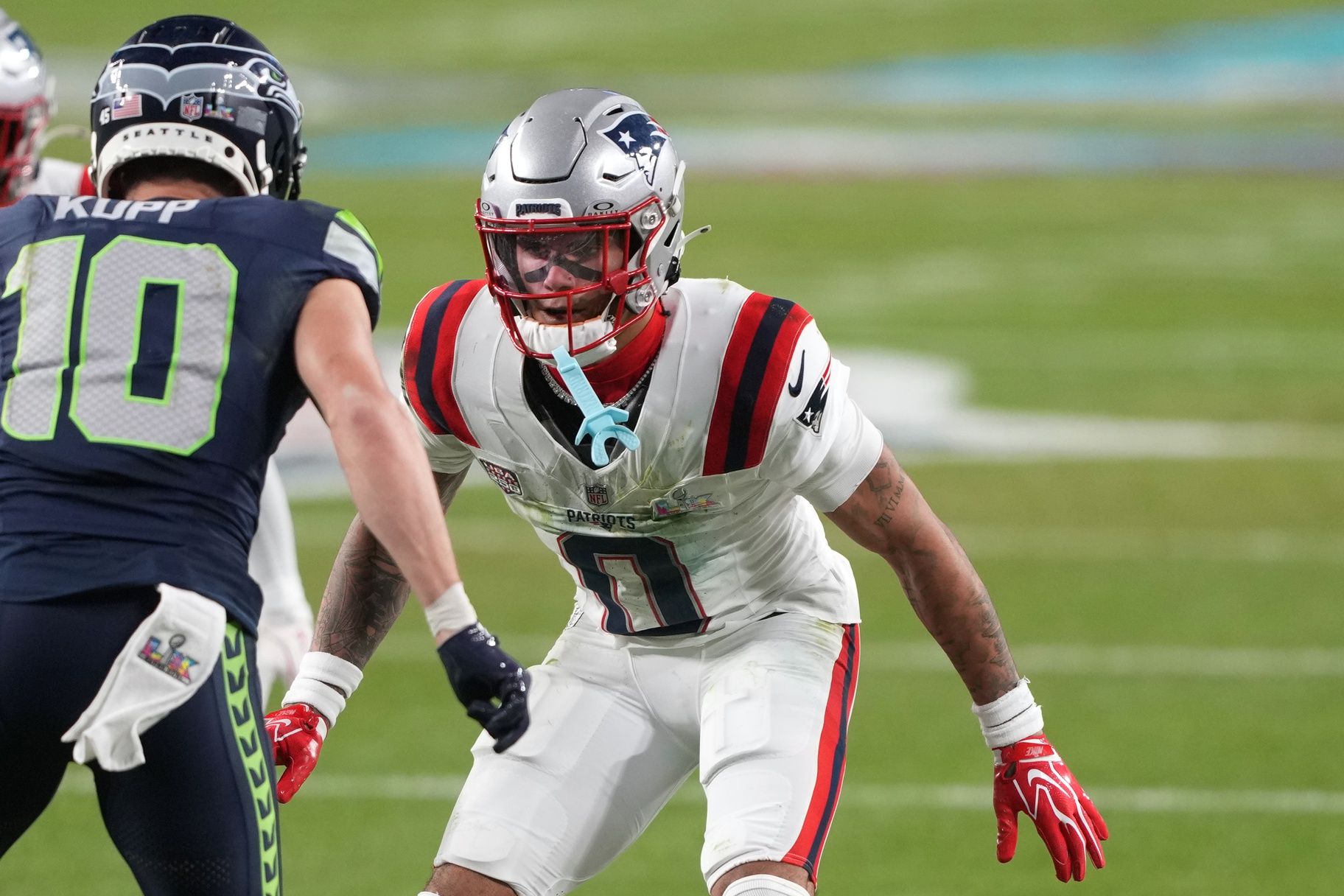 New England Patriots cornerback Christian Gonzalez (0) defends against Seattle Seahawks wide receiver Cooper Kupp (10) during the third quarter in Super Bowl LX at Levi's Stadium.