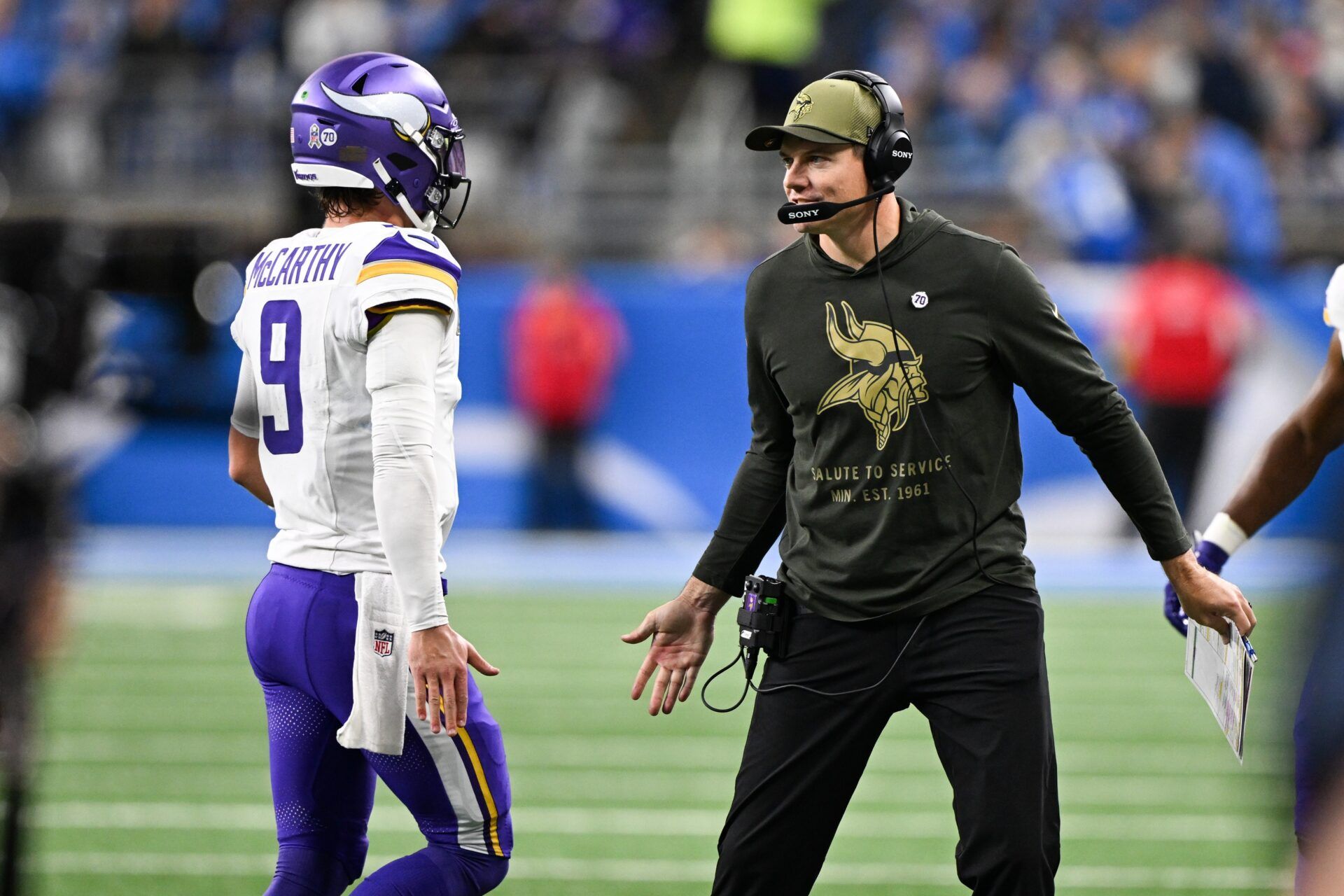 Minnesota Vikings head coach Kevin O'Connell greets quarterback J.J. McCarthy (9) after throwing a touchdown pass in the first quarter at Ford Field.