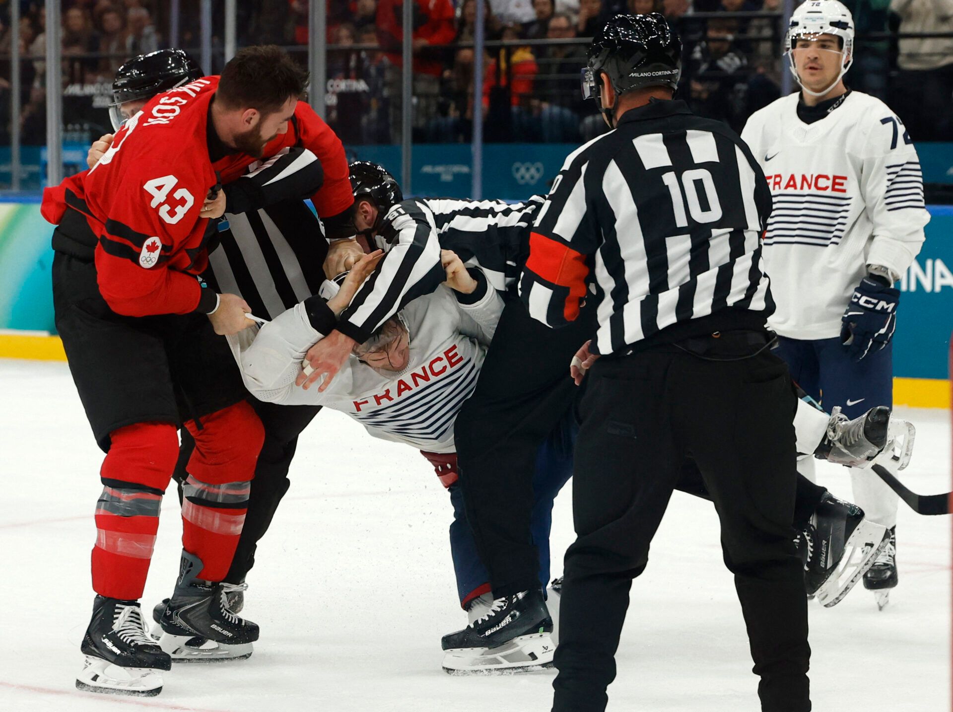 Tom Wilson of Canada clashes with Pierre Crinon of France in men's ice hockey group A play during the Milano Cortina 2026 Olympic Winter Games at Milano Santagiulia Ice Hockey Arena.