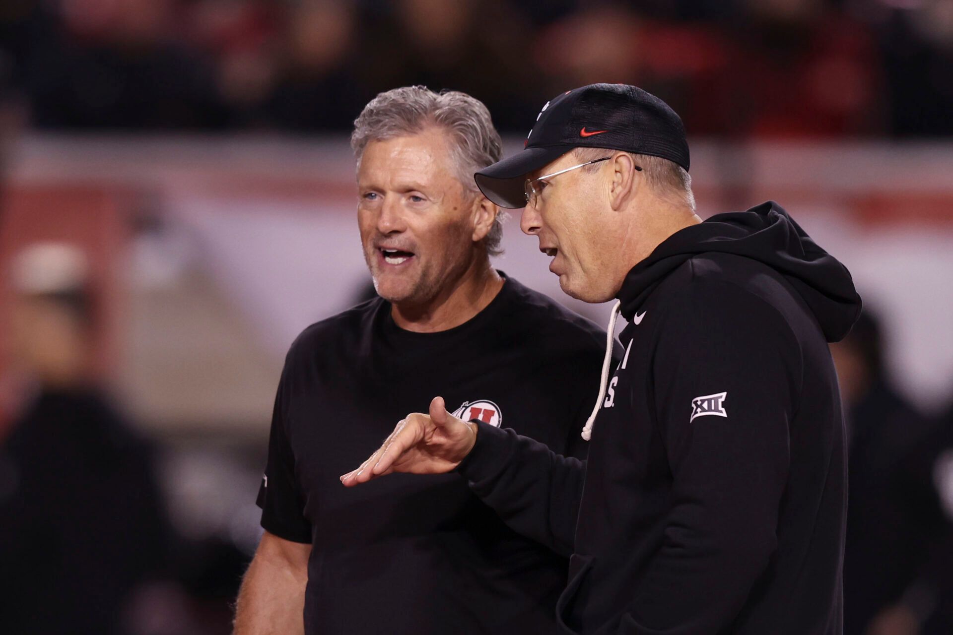 Utah Utes head coach Kyle Whittingham, left, and Cincinnati Bearcats head coach Scott Satterfield, right, speak before the game at Rice-Eccles Stadium.