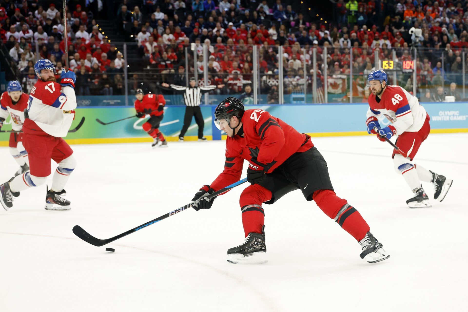 Nathan MacKinnon of Canada controls the puck against Czechia in a men's ice hockey quarterfinal during the Milano Cortina 2026 Olympic Winter Games at Milano Santagiulia Ice Hockey Arena.