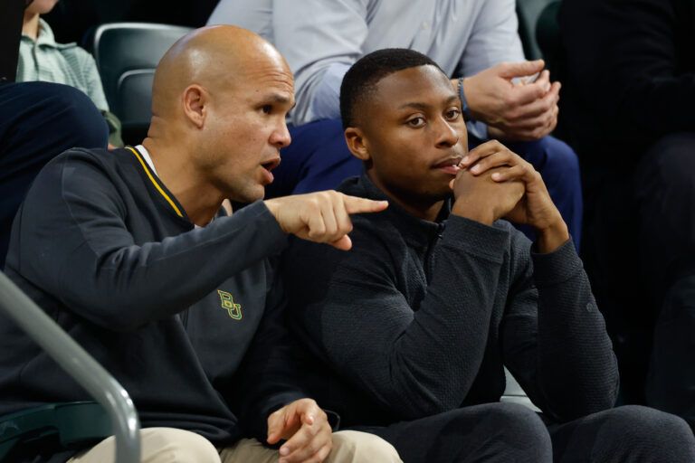 DJ Lagway, a Florida quarterback currently in the transfer portal, sits with Baylor Bears football head coach Dave Aranda, left, during the first half of a game between the Baylor Bears and Iowa State Cyclones at Paul and Alejandra Foster Pavilion.