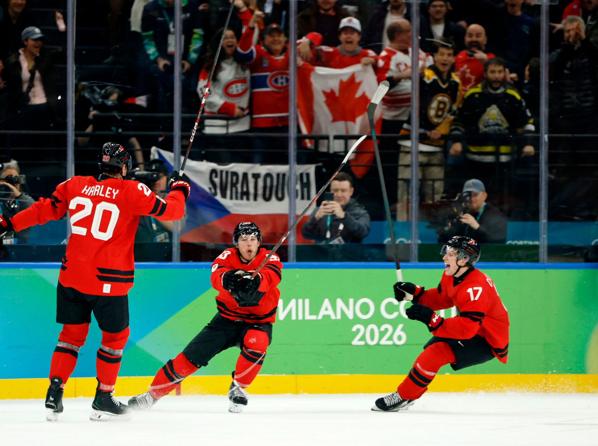 Mitch Marner of Canada celebrates with Thomas Harley and Macklin Celebrini after scoring their fourth and game-winning goal against Czechia in a men's ice hockey quarterfinal during the Milano Cortina 2026 Olympic Winter Games at Milano Santagiulia Ice Hockey Arena.