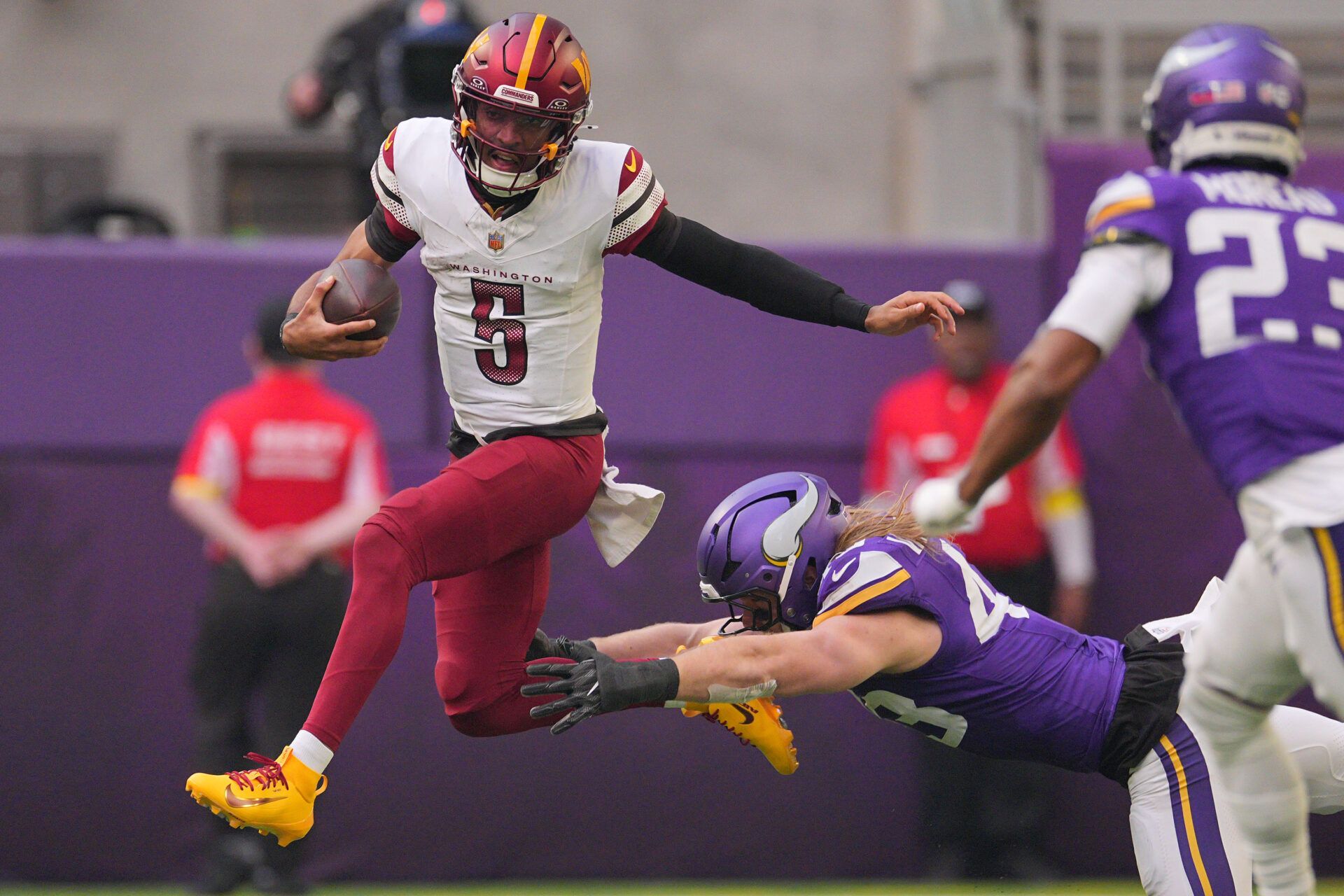 Washington Commanders quarterback Jayden Daniels (5) rushes the ball past Minnesota Vikings outside linebacker Andrew van Ginkel (43) during the first half at U.S. Bank Stadium.