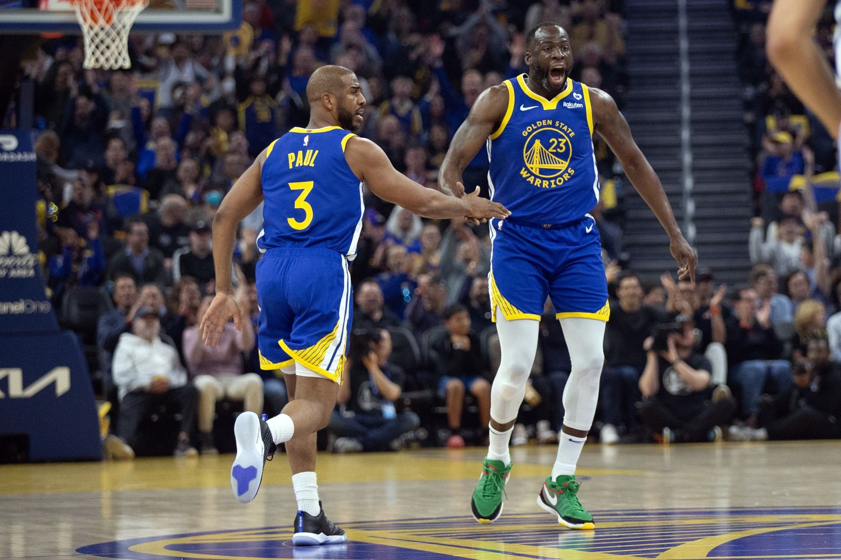 Golden State Warriors forward Draymond Green (23) celebrates his three-point basket with teammate Chris Paul (3) during the first quarter against the San Antonio Spurs at Chase Center.
