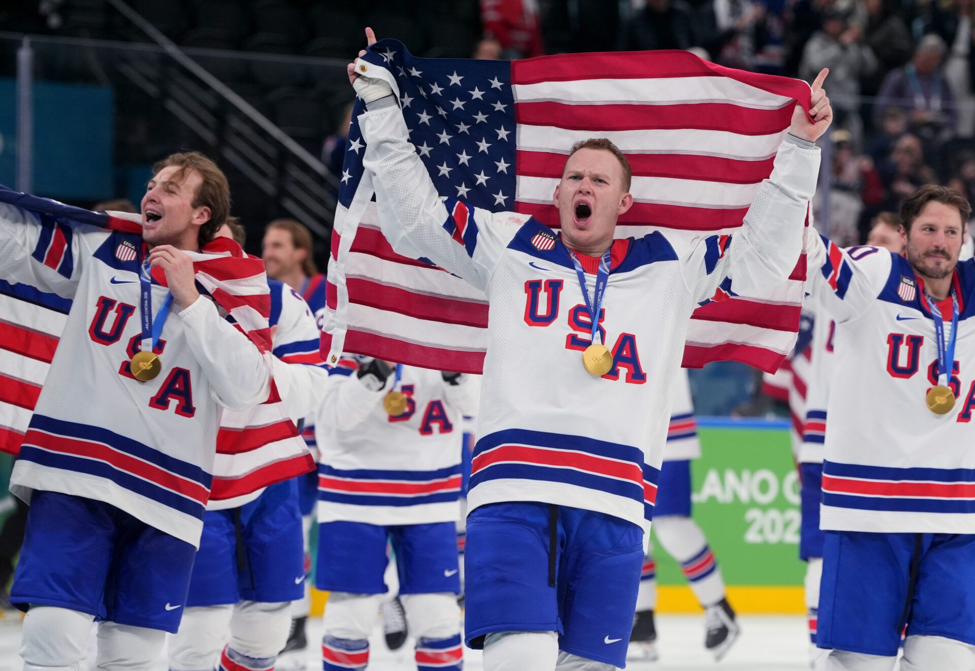 United States players including Brady Tkachuk (7) of the United States celebrate after defeating Canada in the men's ice hockey gold medal game during the Milano Cortina 2026 Olympic Winter Games at Milano Santagiulia Ice Hockey Arena.