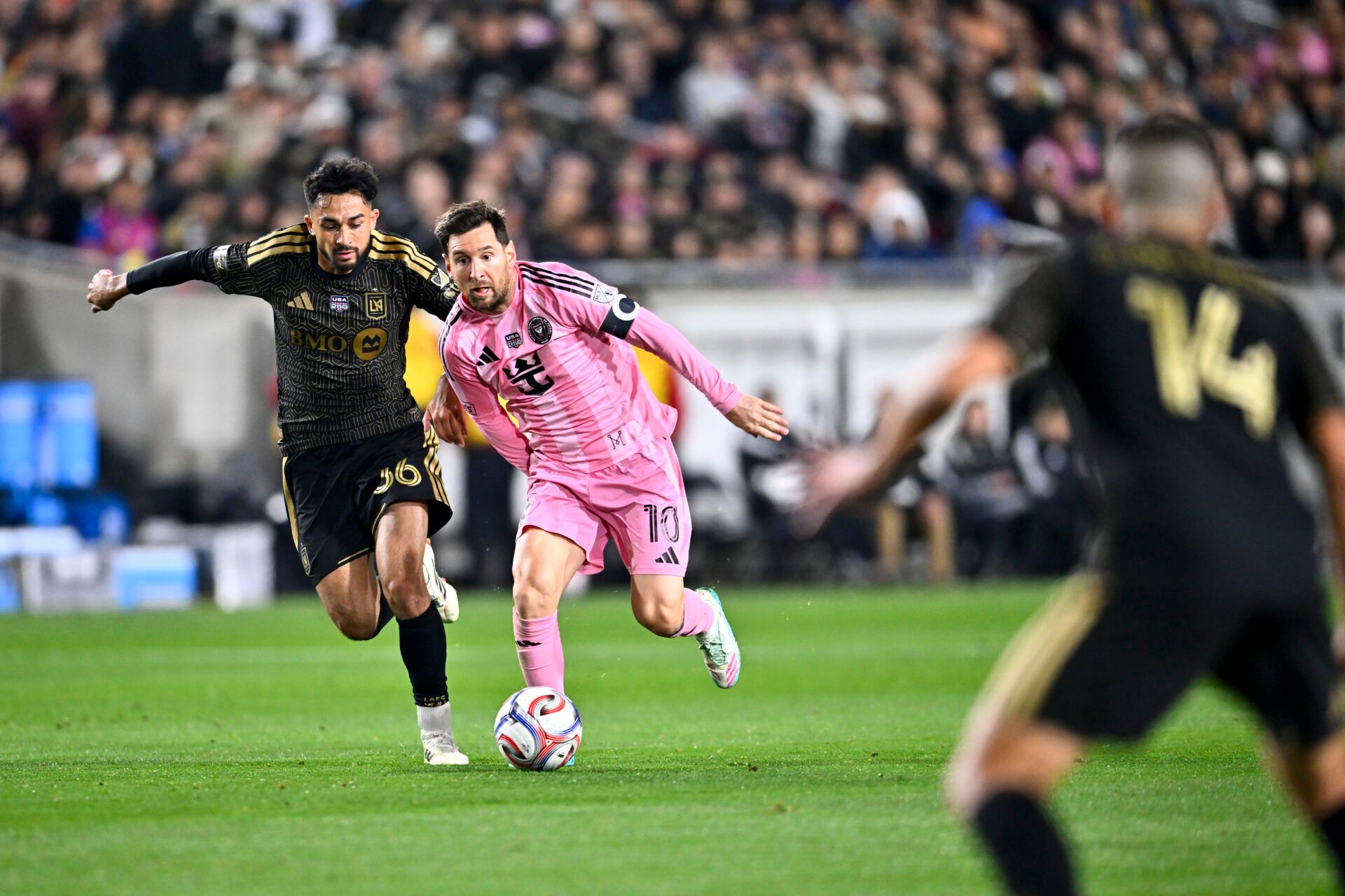 Inter Miami CF forward Lionel Messi (10) moves the ball against Los Angeles FC midfielder Mathieu Choinière (66) during the second half at Los Angeles Memorial Coliseum.