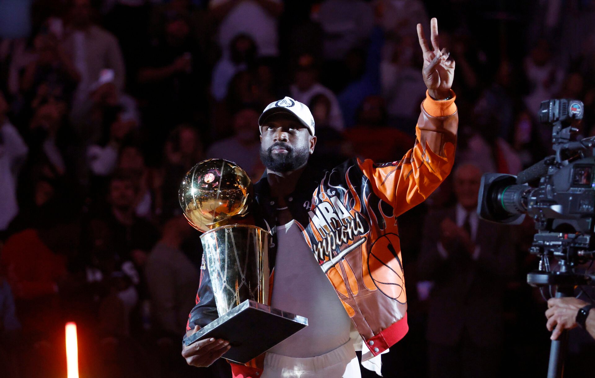 Former Miami Heat guard Dwayne Wade holds the Larry O' Brien trophy during a ceremony to honor 20 years since they won their first NBA Championship during halftime  at Kaseya Center.