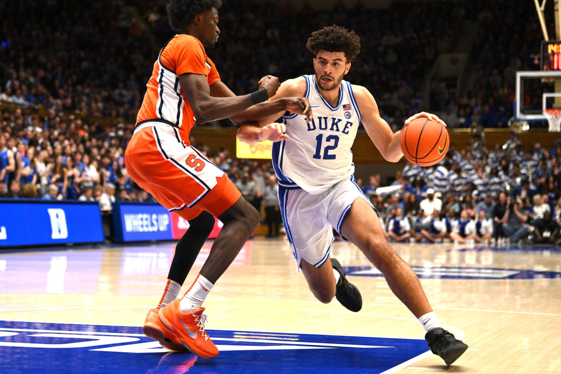 Duke Blue Devils forward Cameron Boozer (12) brings the ball around  Syracuse Orange forward Sadiq White Jr. (0) during the second half at Cameron Indoor Stadium.