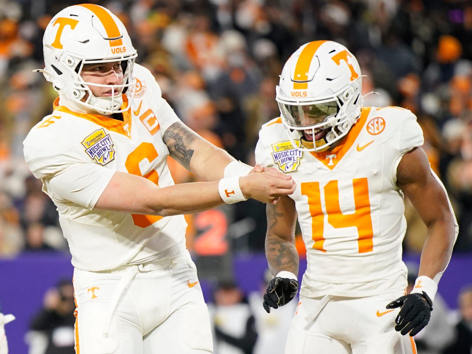 Tennessee quarterback Joey Aguilar (6) celebrating by mimicking a golf swing with wide receiver Braylon Staley (14) after Aguilar ran the ball in for a touchdown during the first quarter of the Music City Bowl against Illinois in an NCAA football game on Dec. 30, 2025, in Nashville, Tennessee.
