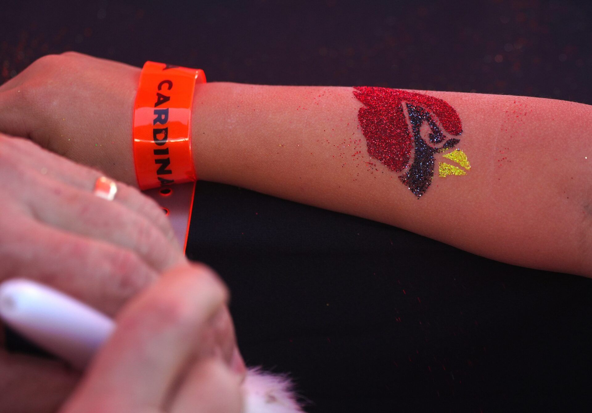 Terry paints a Cardinals logo on a young fan during a Cardinals draft party outside State Farm Stadium in Glendale on April 27, 2023.

Nfl Arizona Cardinals Draft Party At State Farm Stadium Great Lawn