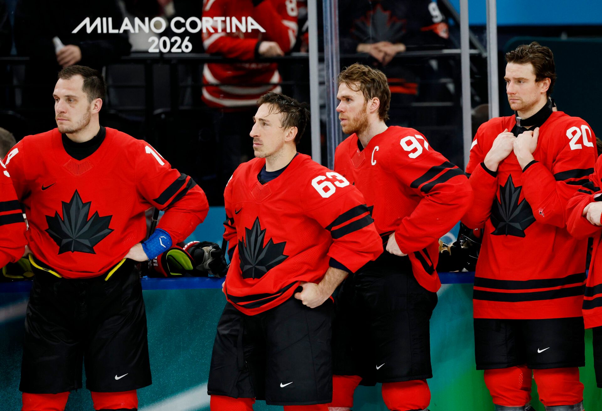 Brad Marchand (63) of Canada and Connor McDavid (97) of Canada react after losing to the United States in the men's ice hockey gold medal game during the Milano Cortina 2026 Olympic Winter Games at Milano Santagiulia Ice Hockey Arena.
