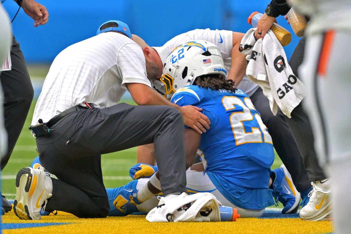 Dr. Frank Petrigliano, team orthopaedic surgeon, right, and staff check on Los Angeles Chargers running back Najee Harris (22) after an injury in the first half against the Denver Broncos at SoFi Stadium.