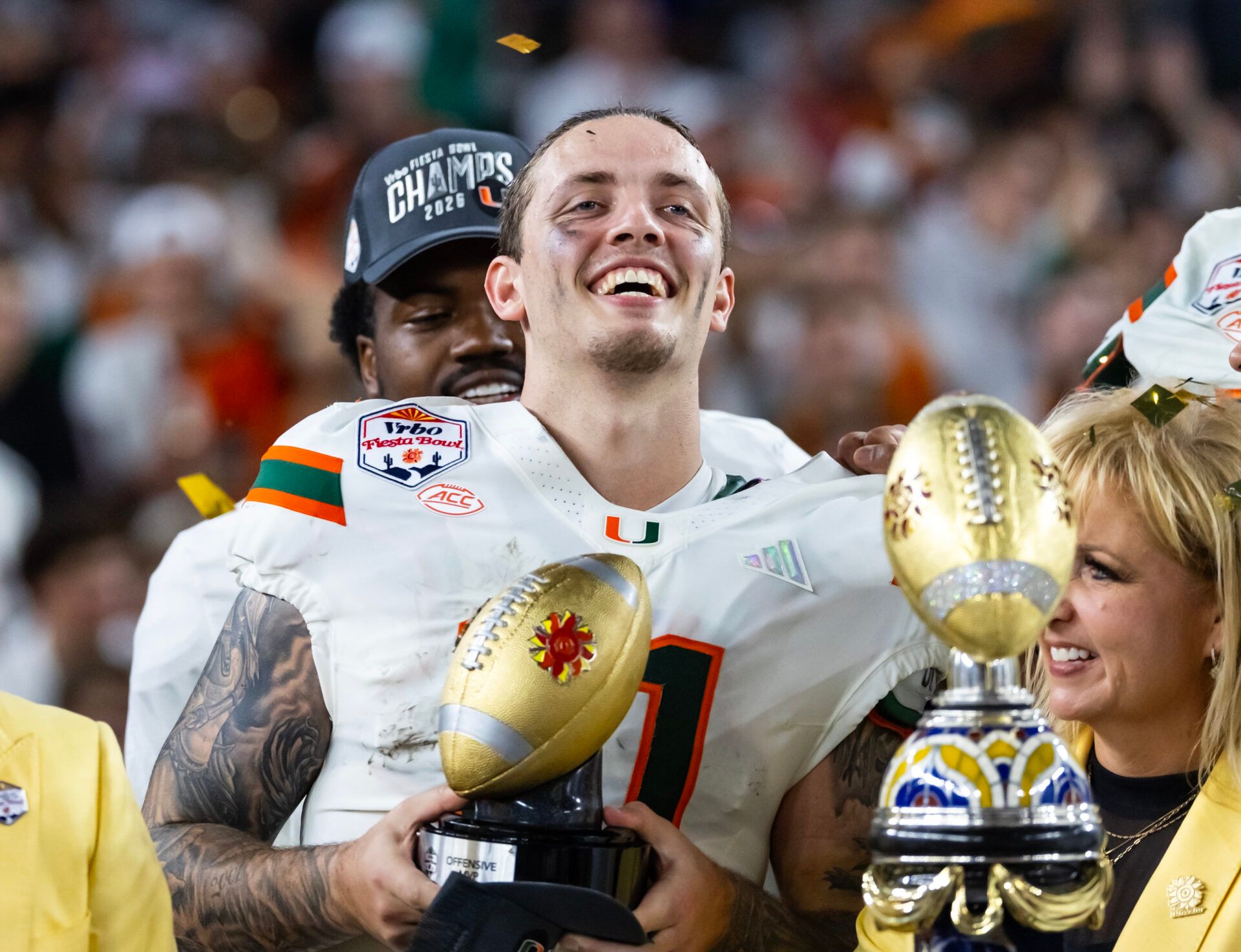Miami Hurricanes quarterback Carson Beck (11) celebrates with the trophy after defeating the Mississippi Rebels during the 2026 Fiesta Bowl and semifinal game of the College Football Playoff at State Farm Stadium.
