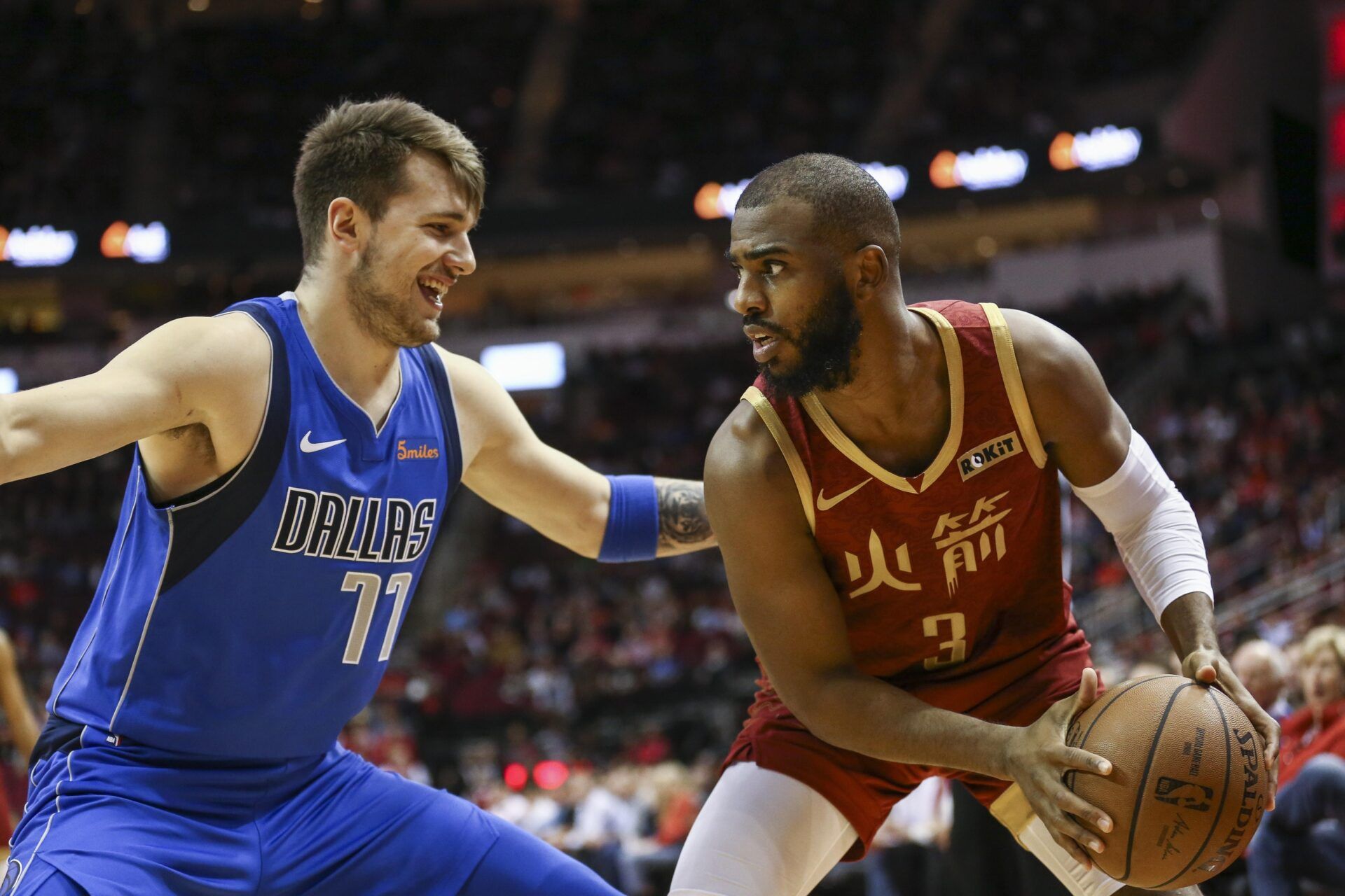 Houston Rockets guard Chris Paul (3) controls the ball as Dallas Mavericks forward Luka Doncic (77) defends during the first quarter at Toyota Center.