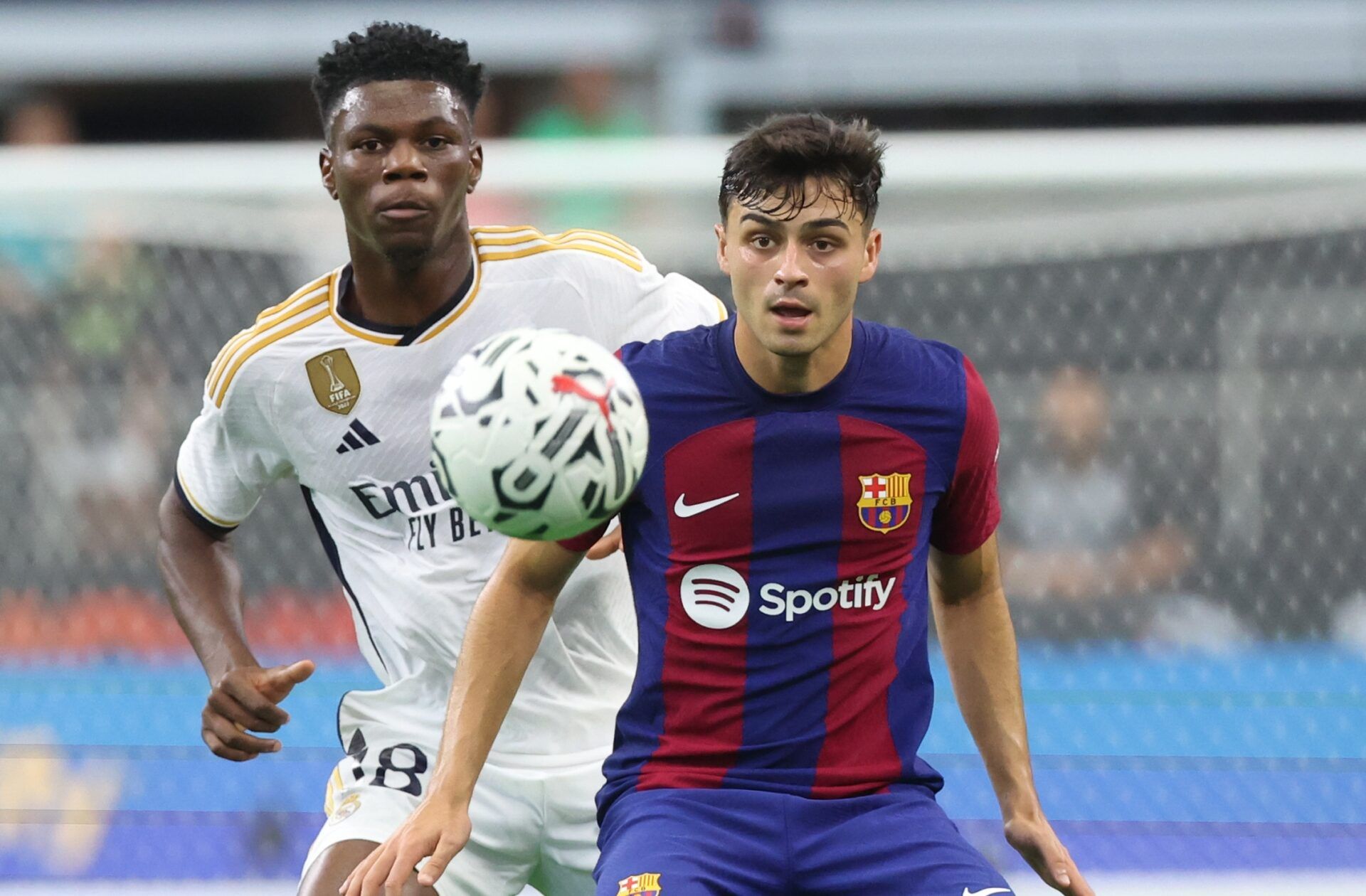 Real Madrid midfielder Aurelien Tchouameni (18) and FC Barcelona midfielder Pedri (8) go for the ball during the first half at AT&T Stadium.