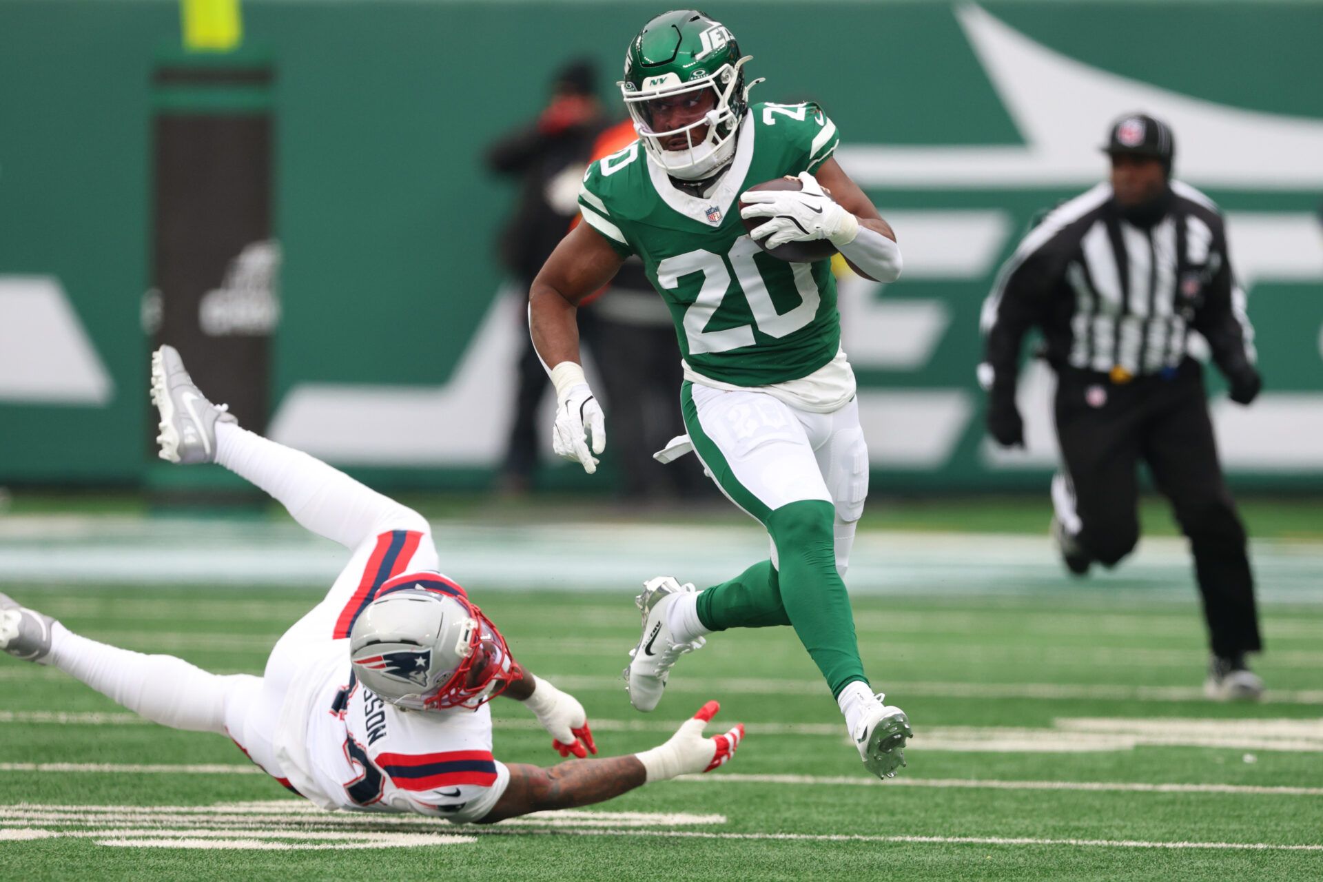 New York Jets running back Breece Hall (20) runs the ball against New England Patriots linebacker K'Lavon Chaisson (44) during the second quarter of the game at MetLife Stadium.