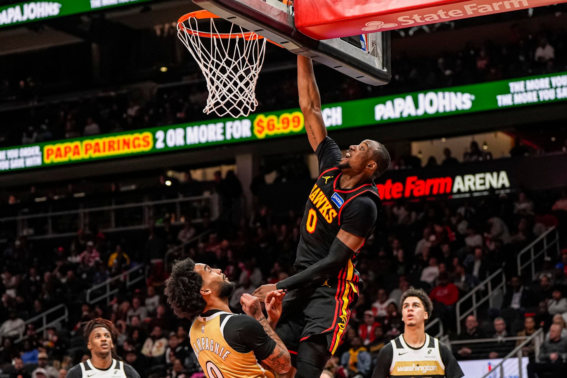 Atlanta Hawks forward Jonathan Kuminga (0)  scores over Washington Wizards forward Justin Champagnie (9) during the second half at State Farm Arena.