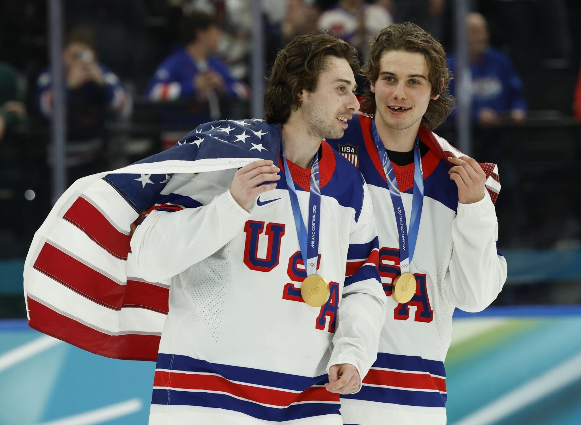 Quinn Hughes (43) of the United States and Jack Hughes (86) of the United States celebrate after defeating Canada in the men's ice hockey gold medal game during the Milano Cortina 2026 Olympic Winter Games at Milano Santagiulia Ice Hockey Arena.
