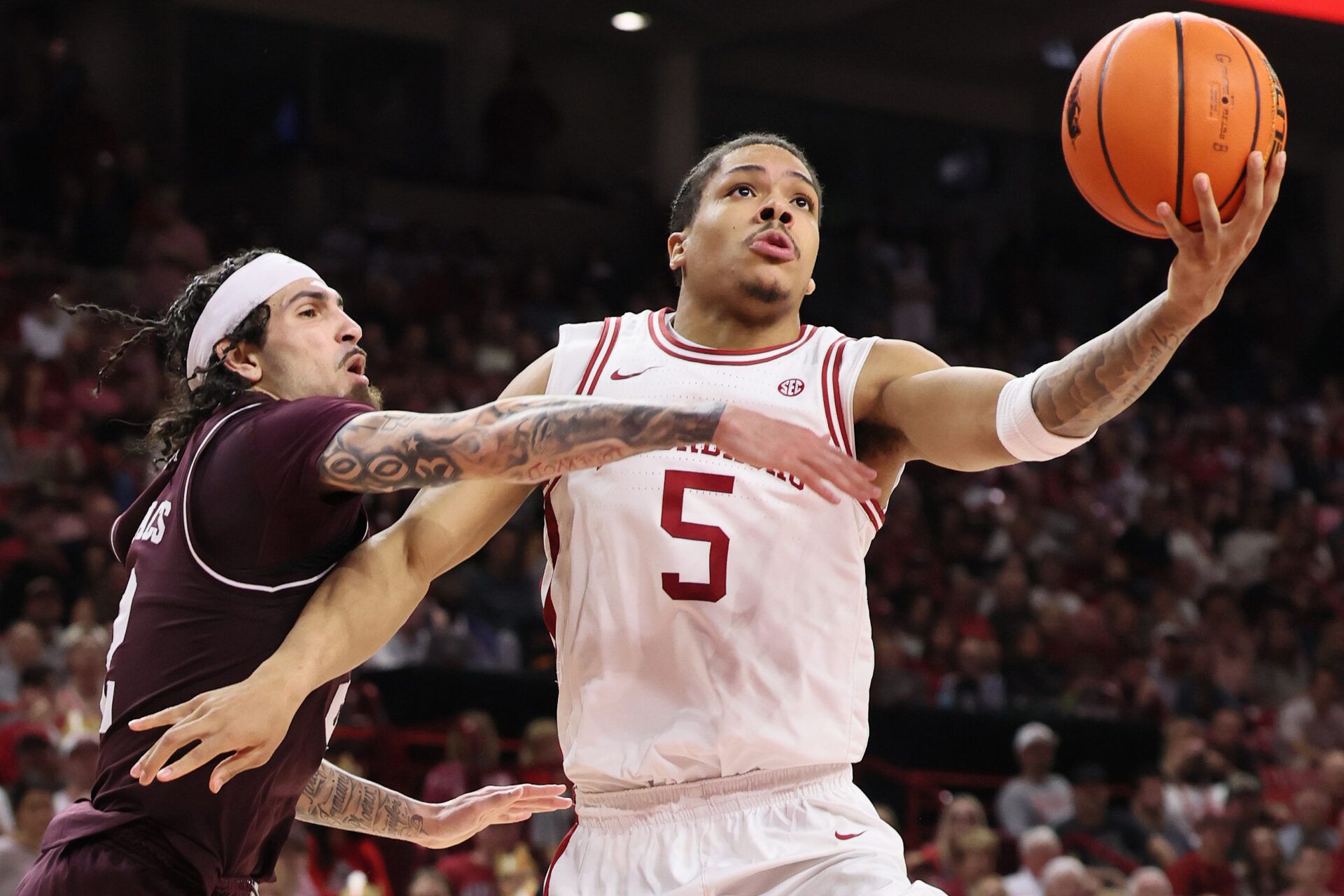 Arkansas Razorbacks guard Darius Acuff Jr. (5) drives to the basket as Texas A&M Aggies guard Pop Isaacs (2) defends during the second half at Bud Walton Arena. Arkansas won 99-84.