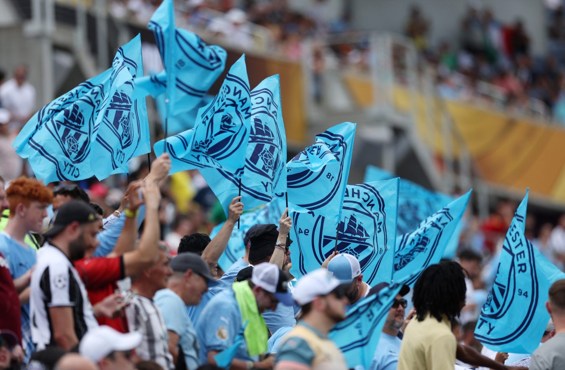Manchester City fans wave flags during the first half during a group stage match of the 2025 FIFA Club World Cup at Camping World Stadium.
