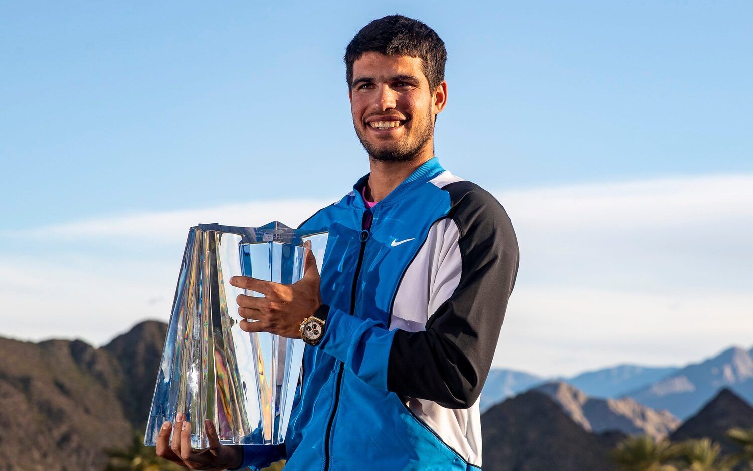 2024 BNP Paribas Open Champion Carlos Alcaraz poses for a photo with his trophy on a deck at Stadium 1 with the Santa Rosa mountains in the background in Indian Wells, Calif., Sunday, March 17, 2024.