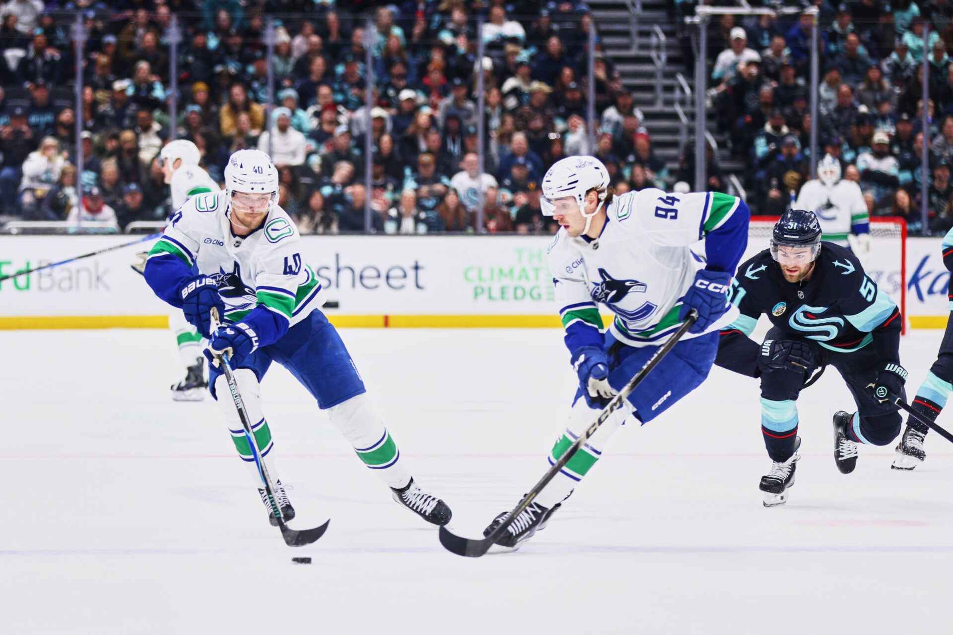 Vancouver Canucks center Elias Pettersson (40) collects the puck from Vancouver Canucks center Linus Karlsson (94) during the first period against the Seattle Kraken at Climate Pledge Arena.