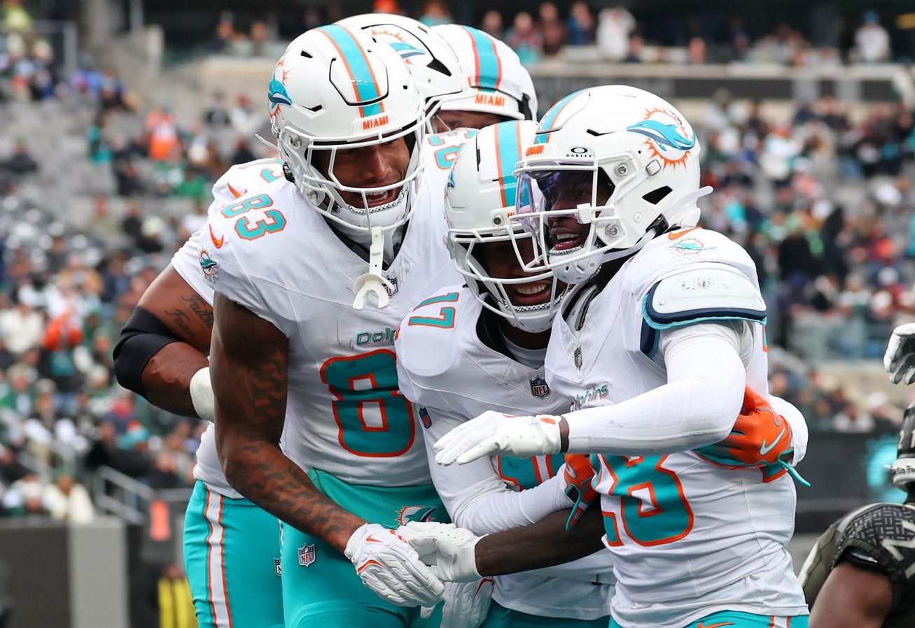 Miami Dolphins running back De'Von Achane (28) celebrates with tight end Darren Waller (83) and wide receiver Jaylen Waddle (17) after scoring a touchdown against the New York Jets during the first half at MetLife Stadium.