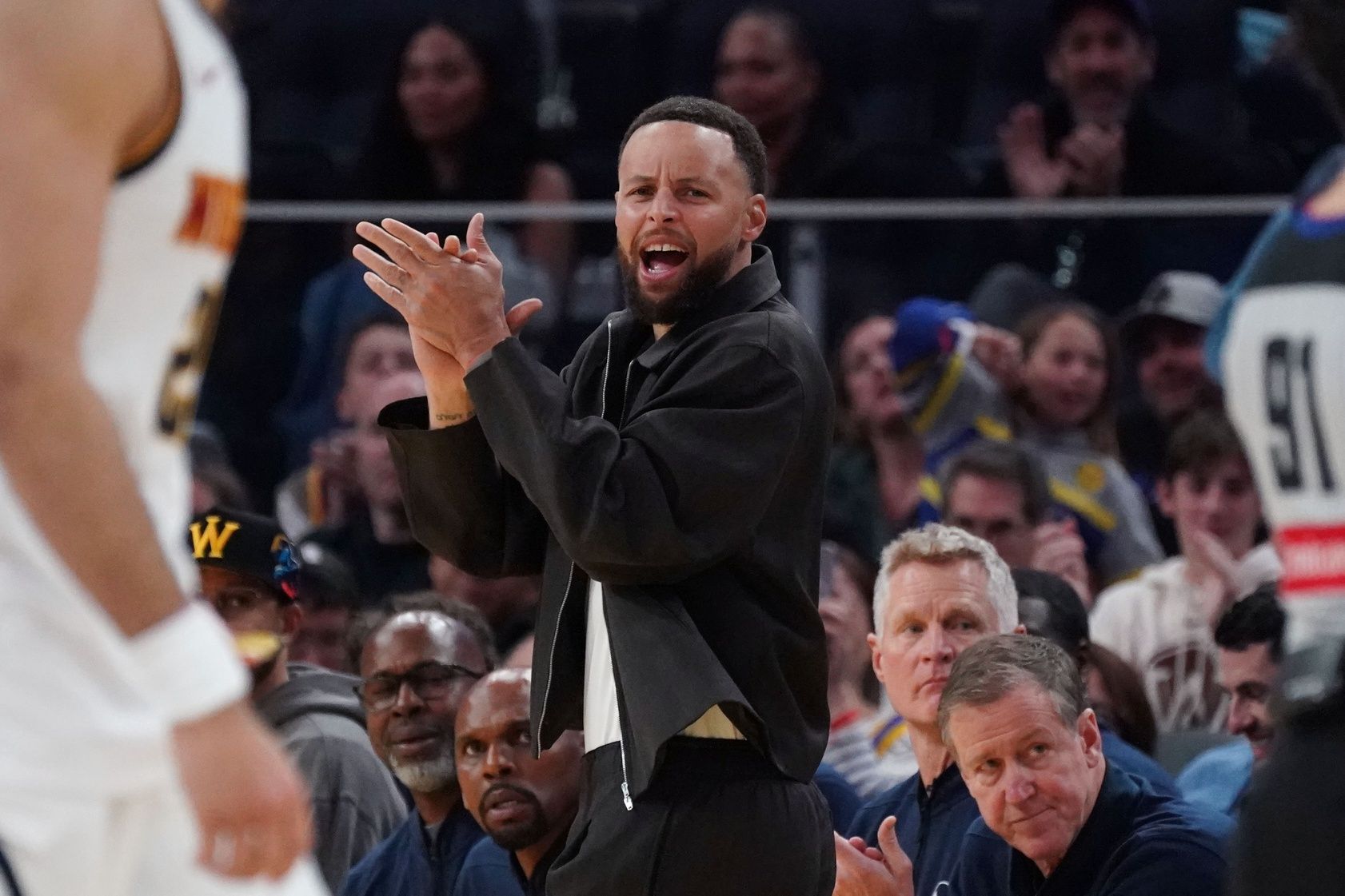 Golden State Warriors guard Stephen Curry (30) cheers from the bench during a game against the Denver Nuggets in the third quarter at Chase Center.