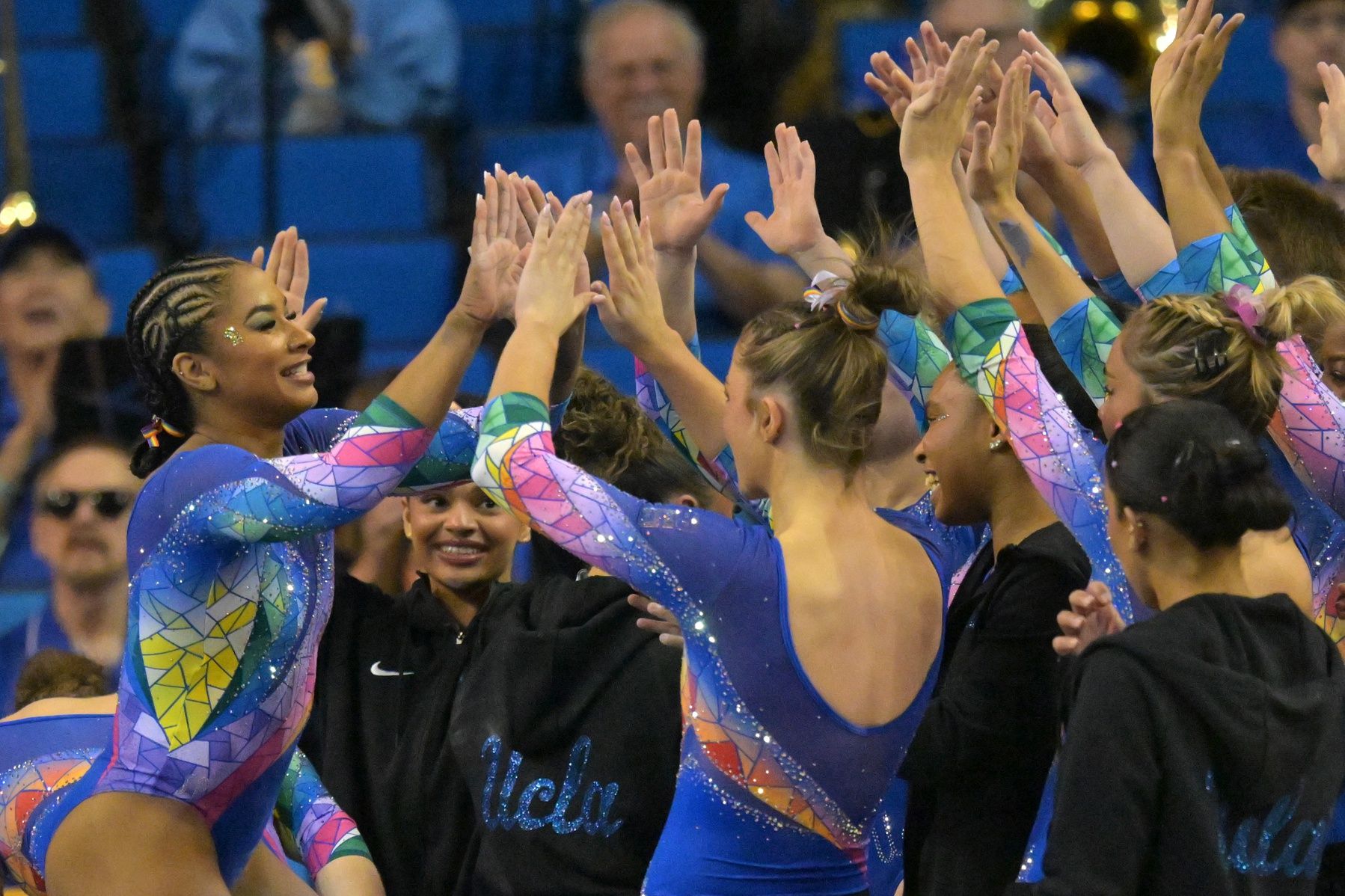 UCLA Bruins Jordan Chiles gets high fives after her performance on the balance beam during the gymnastics meet against the Washington Huskies at Pauley Pavilion.
