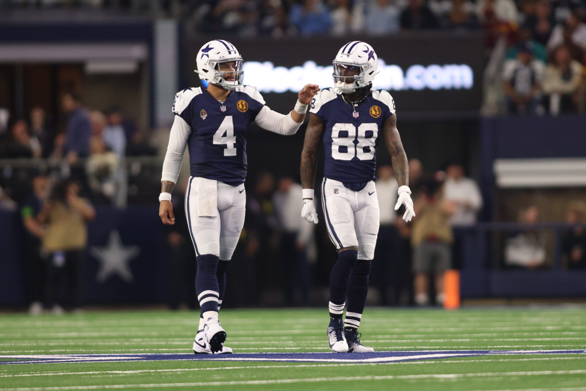 Dallas Cowboys wide receiver CeeDee Lamb (88) and quarterback Dak Prescott (4) talk during the game against the Washington Commanders at AT&T Stadium.