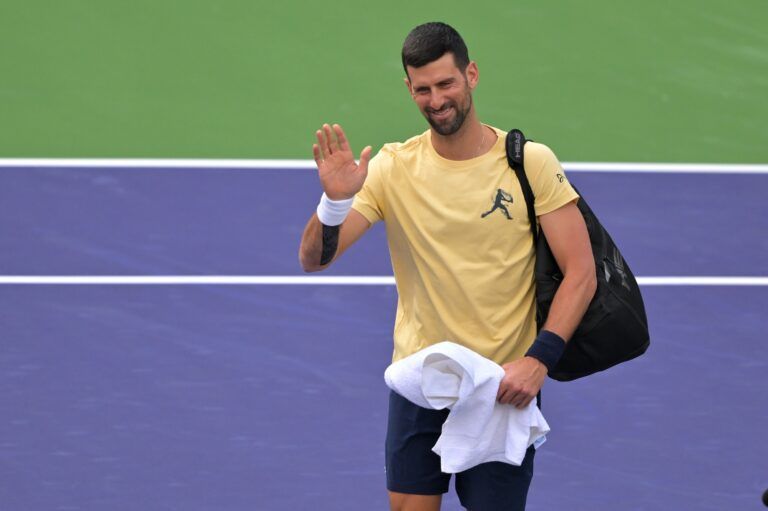 Novak Djokovic (SRB) waves to fans as he enters the court for a practice session for the BNP Paribas Open at the Indian Wells Tennis Garden.