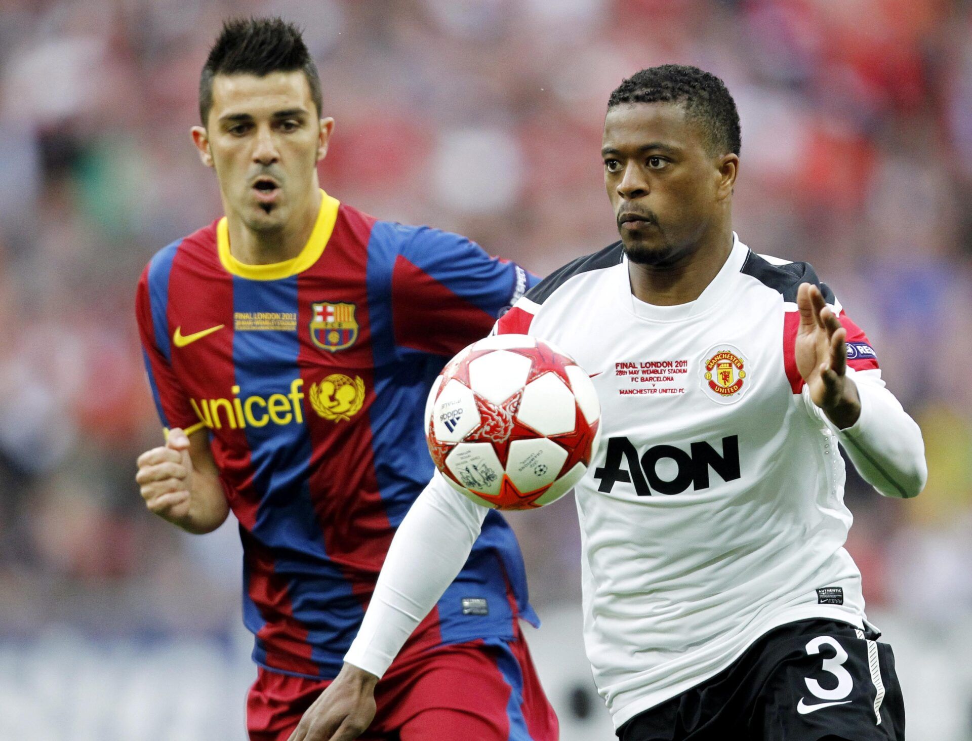 FC Barcelona player David Villa (left) chases after the ball with Manchester United player Patrice Evra (right) during the 2011 UEFA Champions League final at Wembley Stadium.