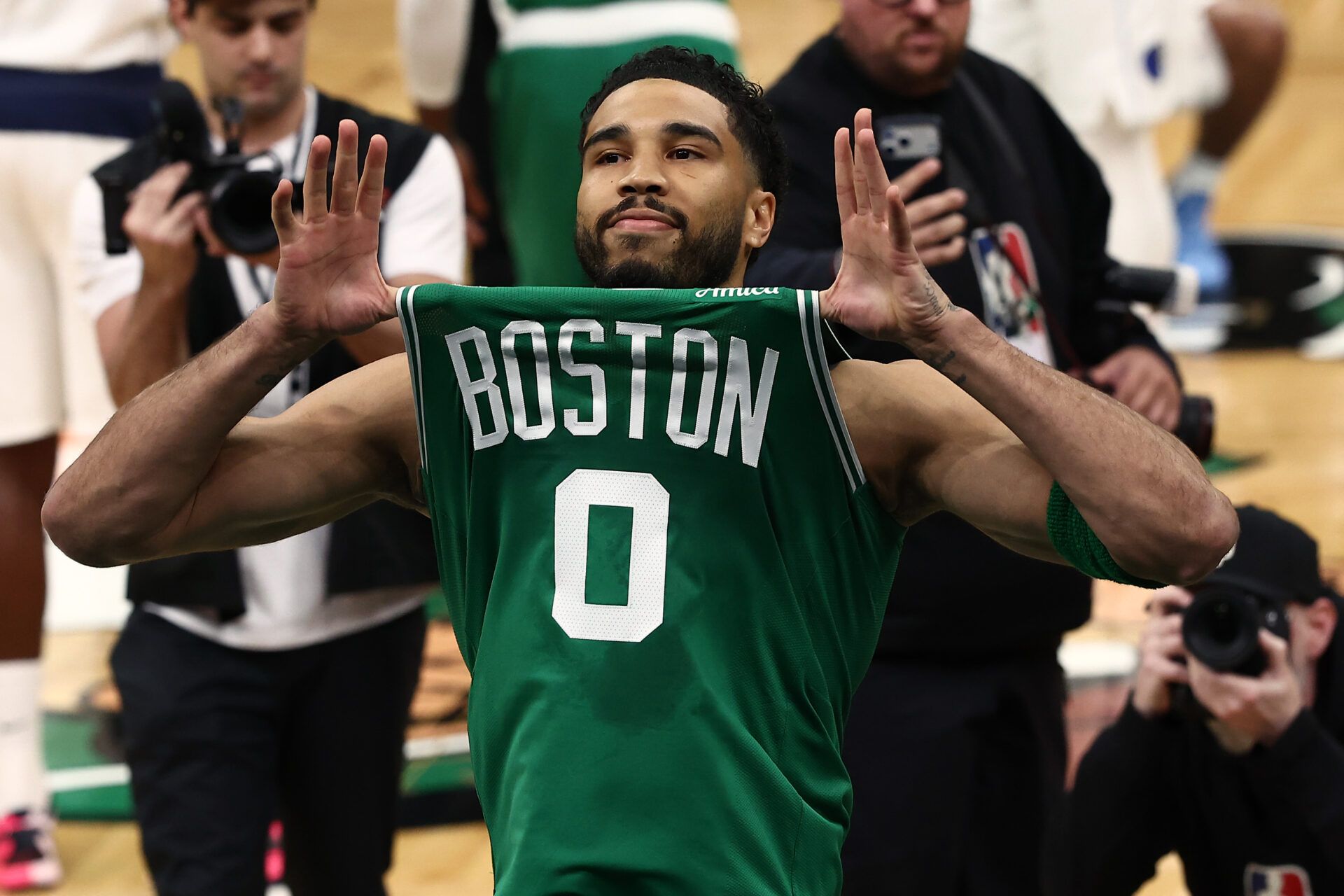 Boston Celtics forward Jayson Tatum (0) shows his jersey to the crowd before taking the court for the first quarter against the Dallas Mavericks at TD Garden.