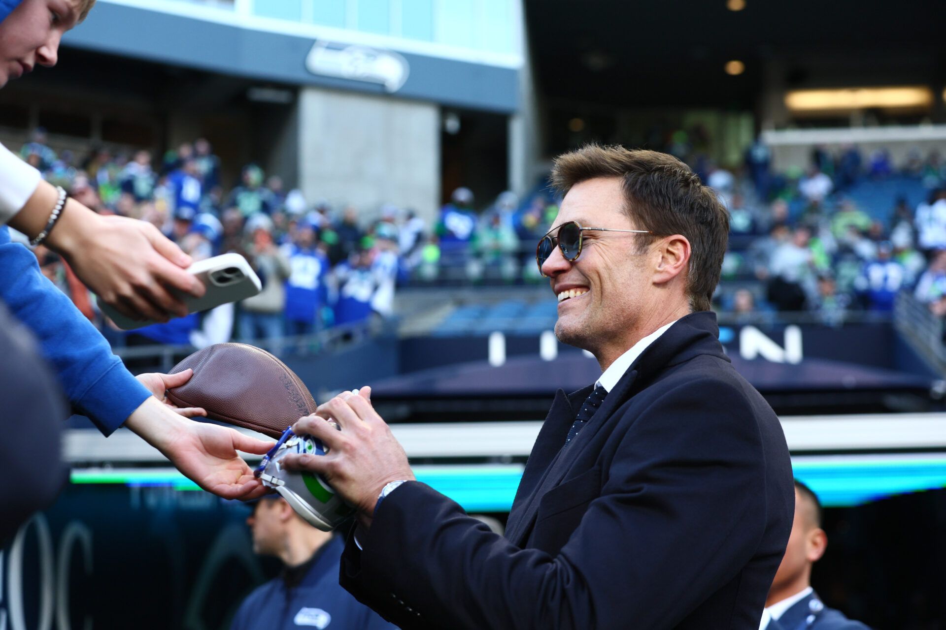 Tom Brady signs autographs before the 2026 NFC Championship Game between the Seattle Seahawks and the Los Angeles Rams at Lumen Field.
