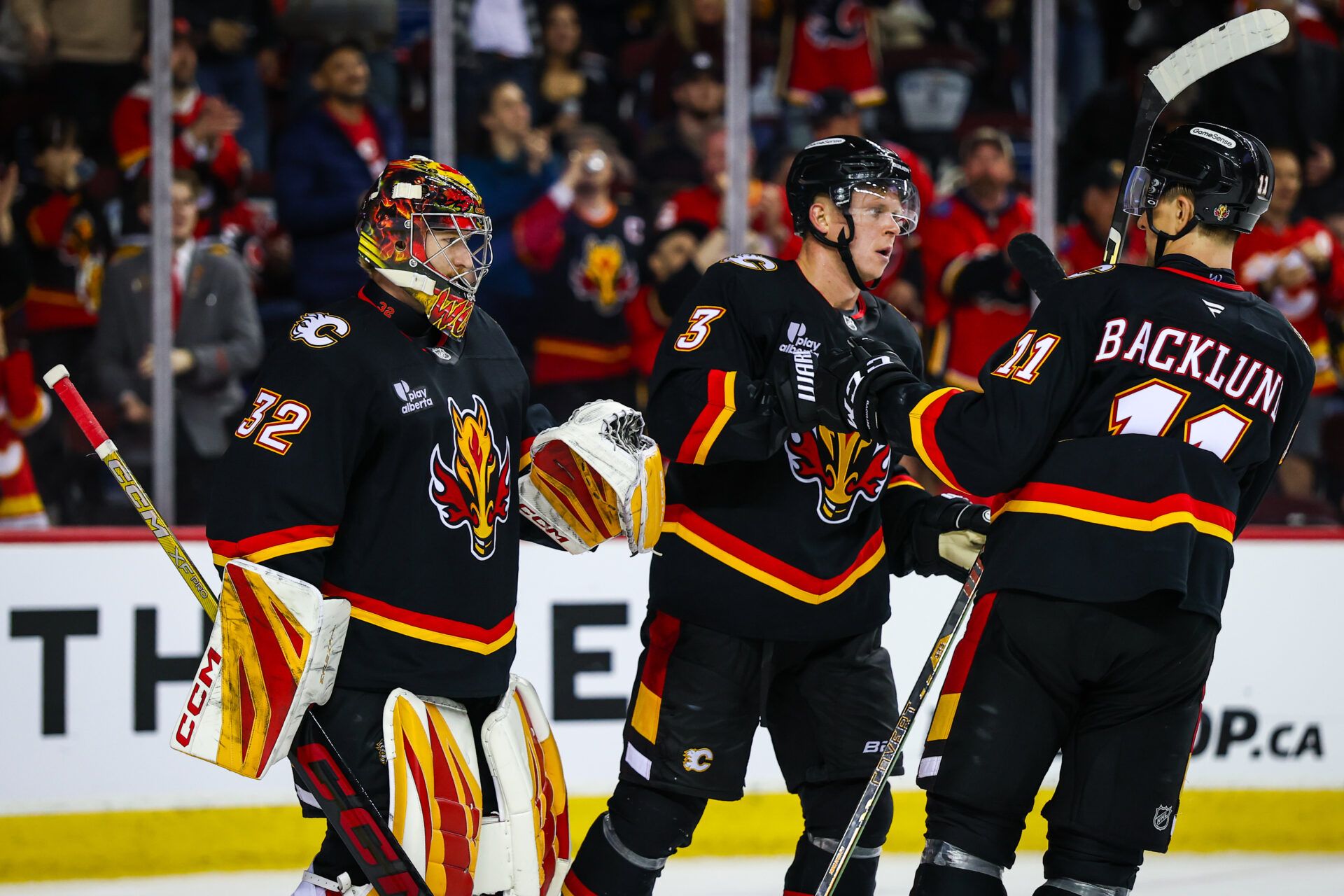 Calgary Flames goaltender Dustin Wolf (32) celebrates win with teammates after defeating Carolina Hurricanes at Scotiabank Saddledome.