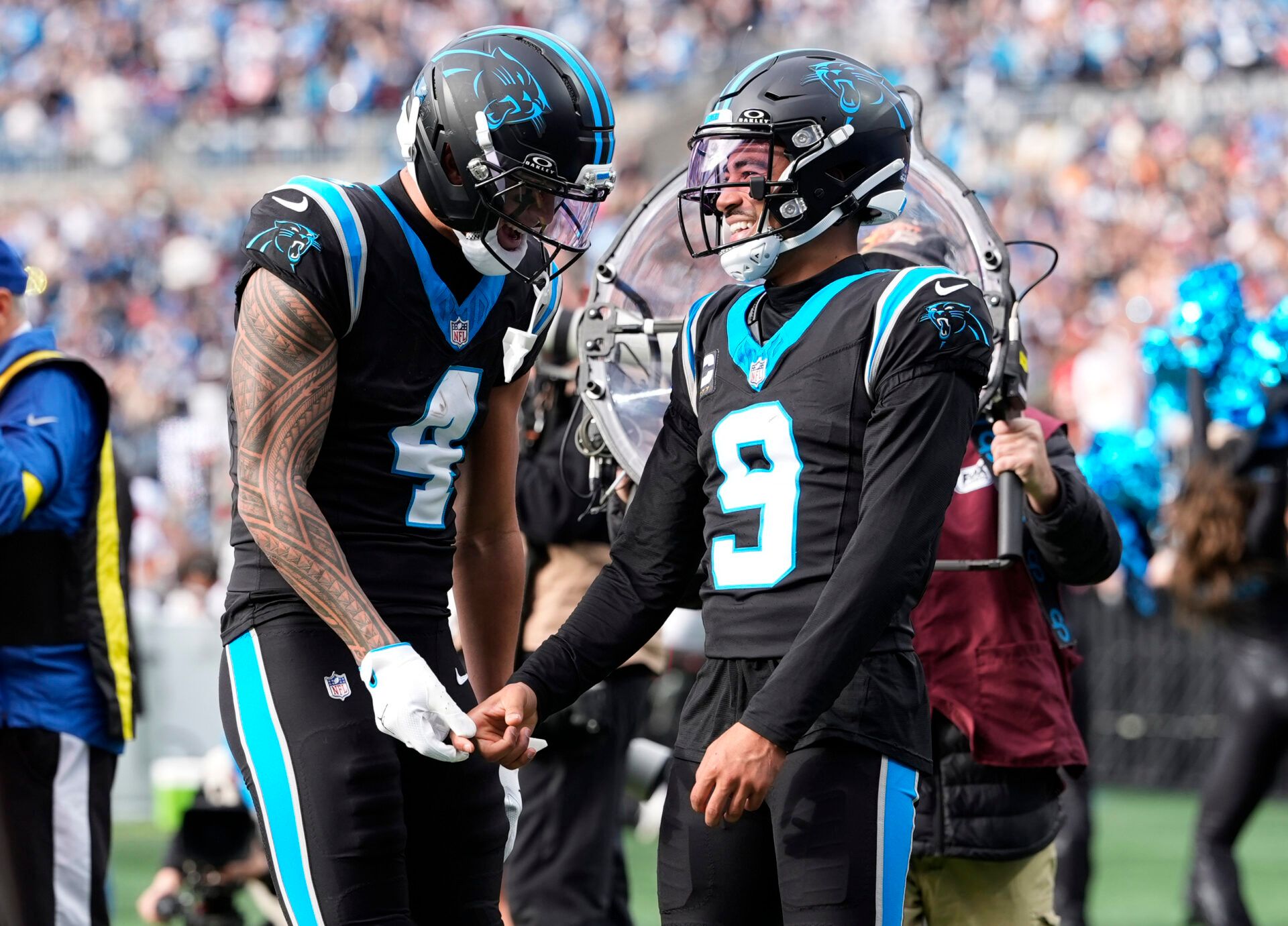 Carolina Panthers wide receiver Tetairoa McMillan (4) and quarterback Bryce Young (9) celebrate after a play during the second half against the Tampa Bay Buccaneers at Bank of America Stadium.