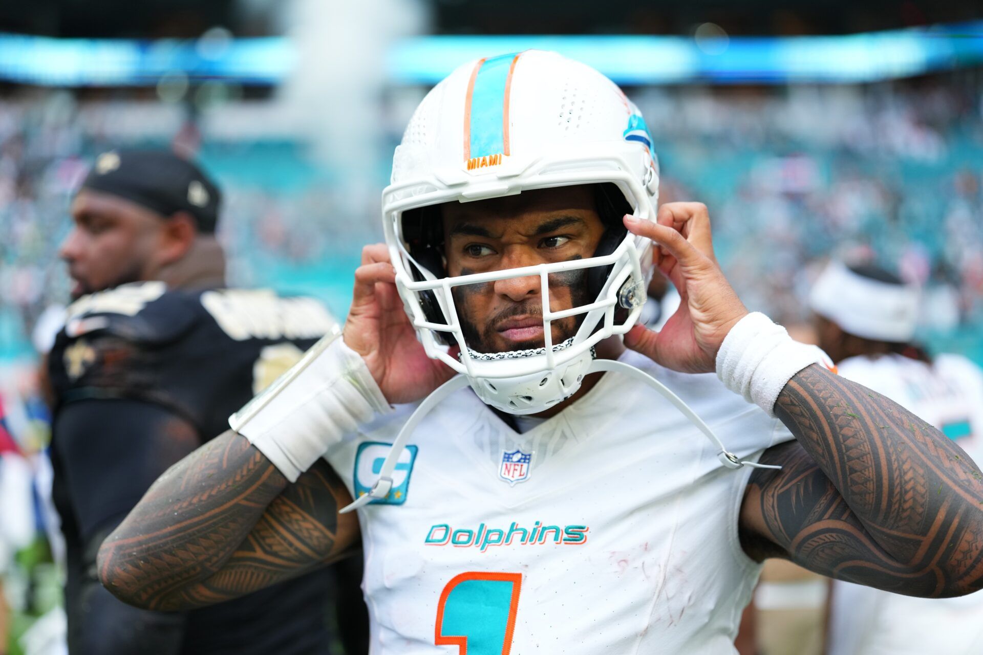 Miami Dolphins quarterback Tua Tagovailoa (1) takes off his helmet following a game against the New Orleans Saints at Hard Rock Stadium.