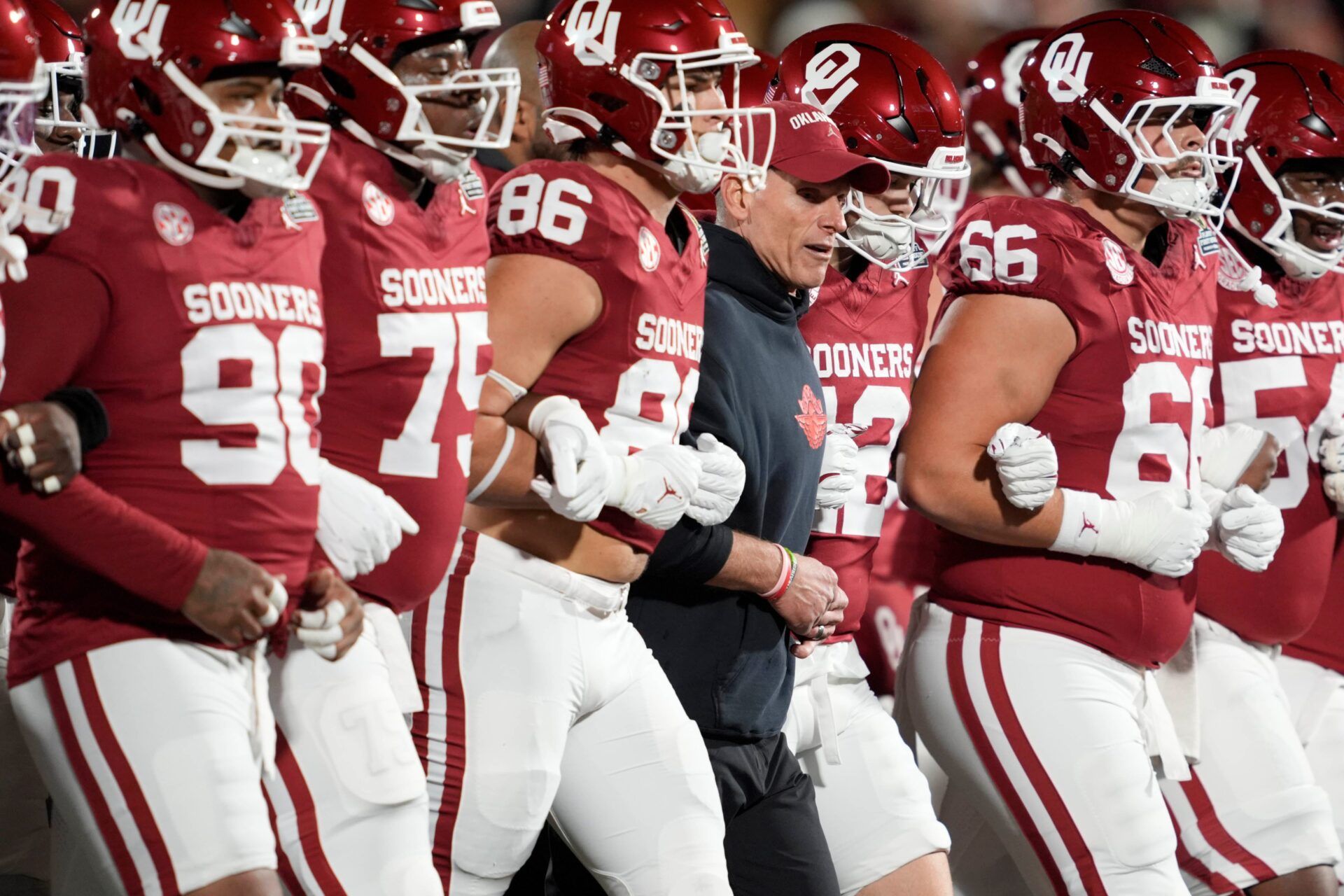 Oklahoma coach Brent Venables locks arms with players before a first-round College Football Playoff game between the University of Oklahoma Sooners (OU) and the Alabama Crimson Tide at Gaylord Family – Oklahoma Memorial Stadium in Norman, Okla., Friday, Dec. 19, 2025.