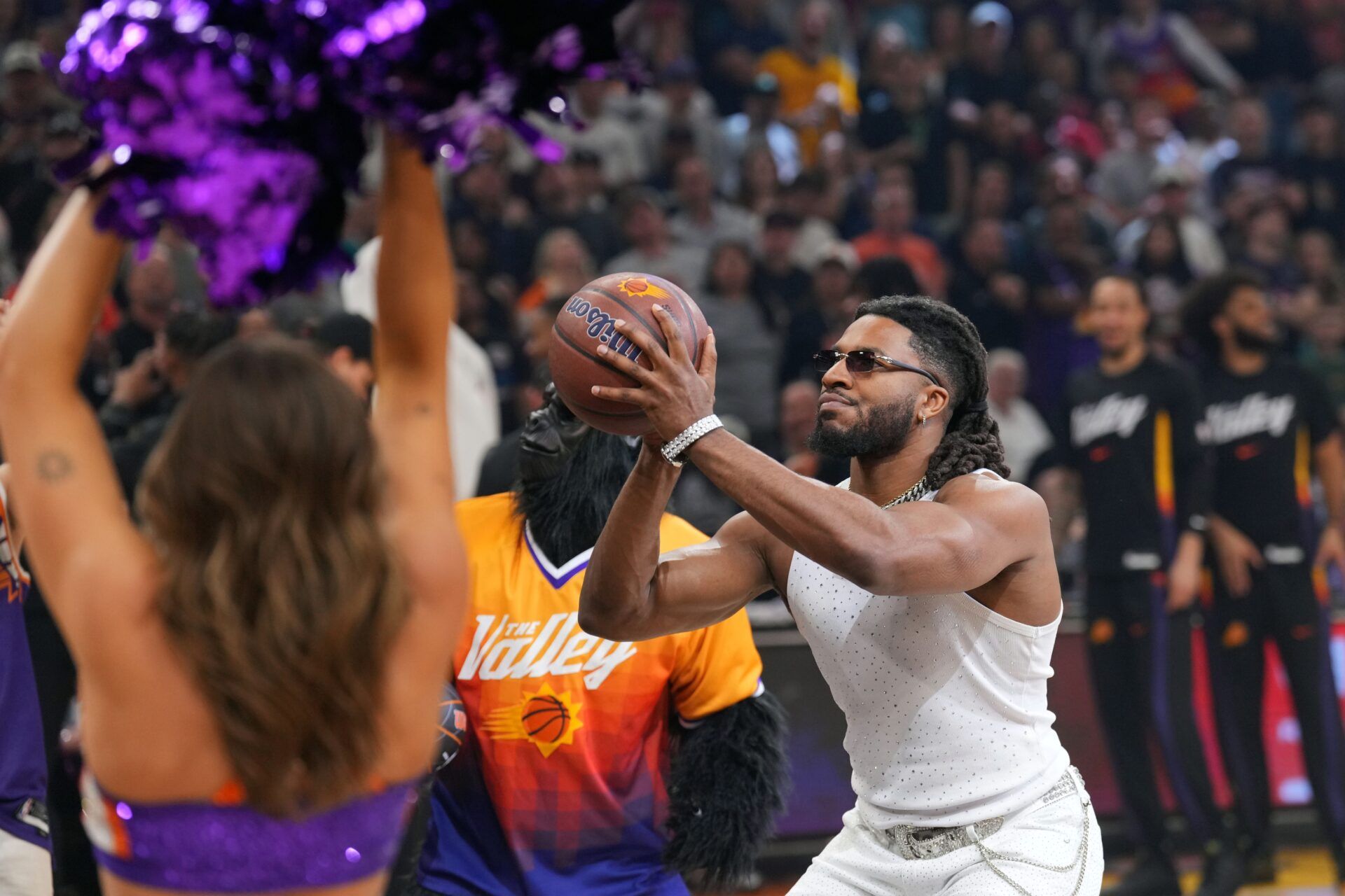 WWE wrestler Trick Williams takes the opening shot before the first half of the game between the Phoenix Suns and the Charlotte Hornets at Mortgage Matchup Center.