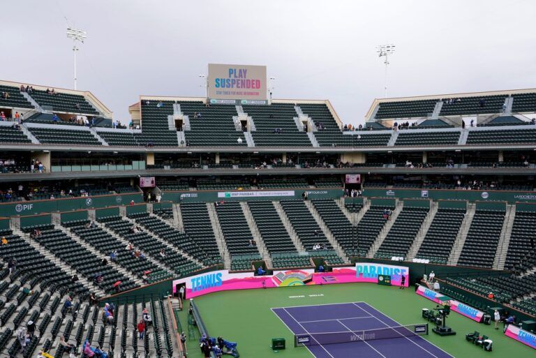 Some tennis fans linger in a mostly empty Stadium 1 as morning rain suspends play between Iga Swiatek and Karolina Muchova at the BNP Paribas Open in Indian Wells, Calif., on Tuesday, March 11, 2025.