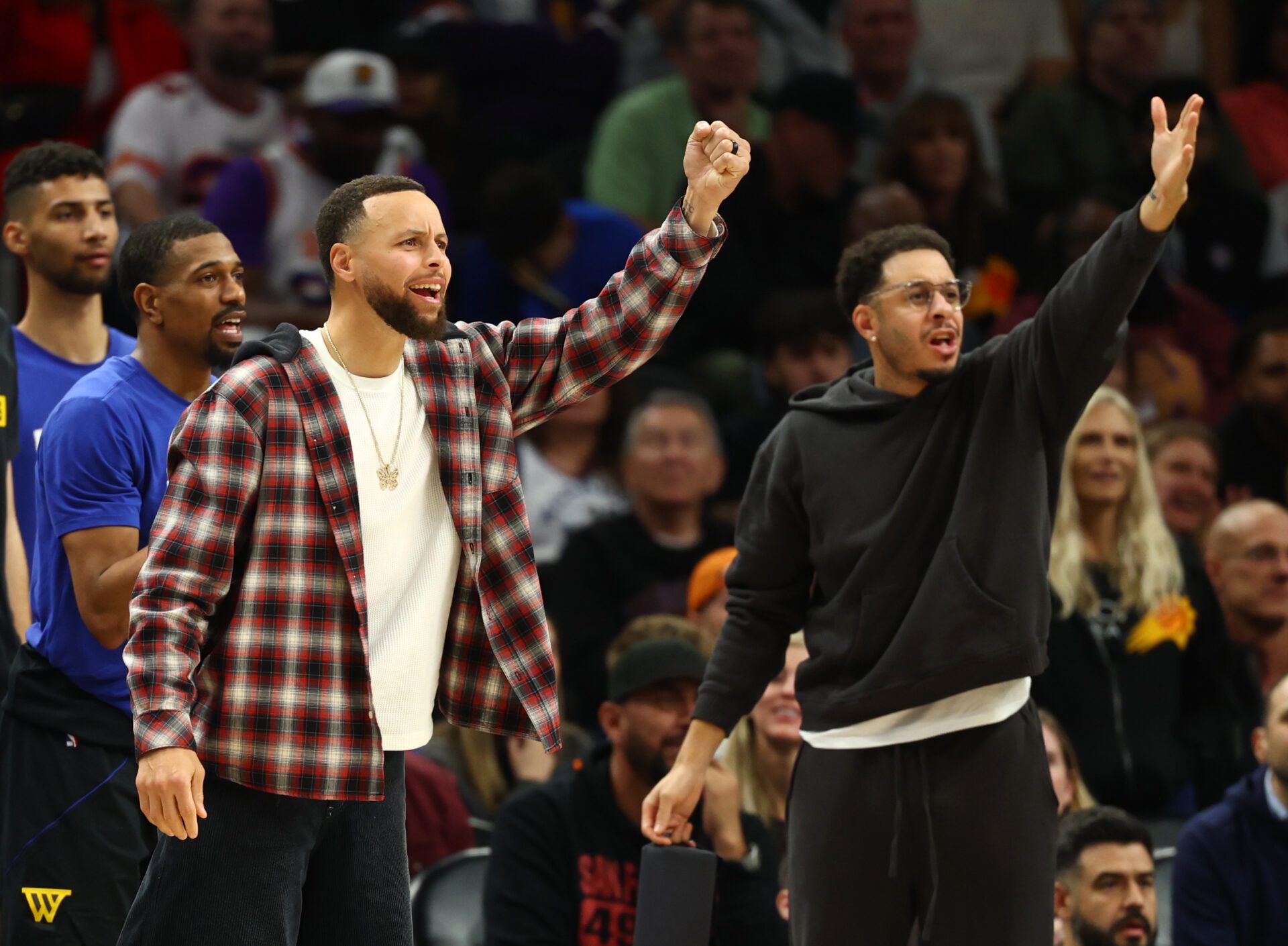 Golden State Warriors guard Stephen Curry (left) and brother Seth Curry react against the Phoenix Suns in the second half at Mortgage Matchup Center.