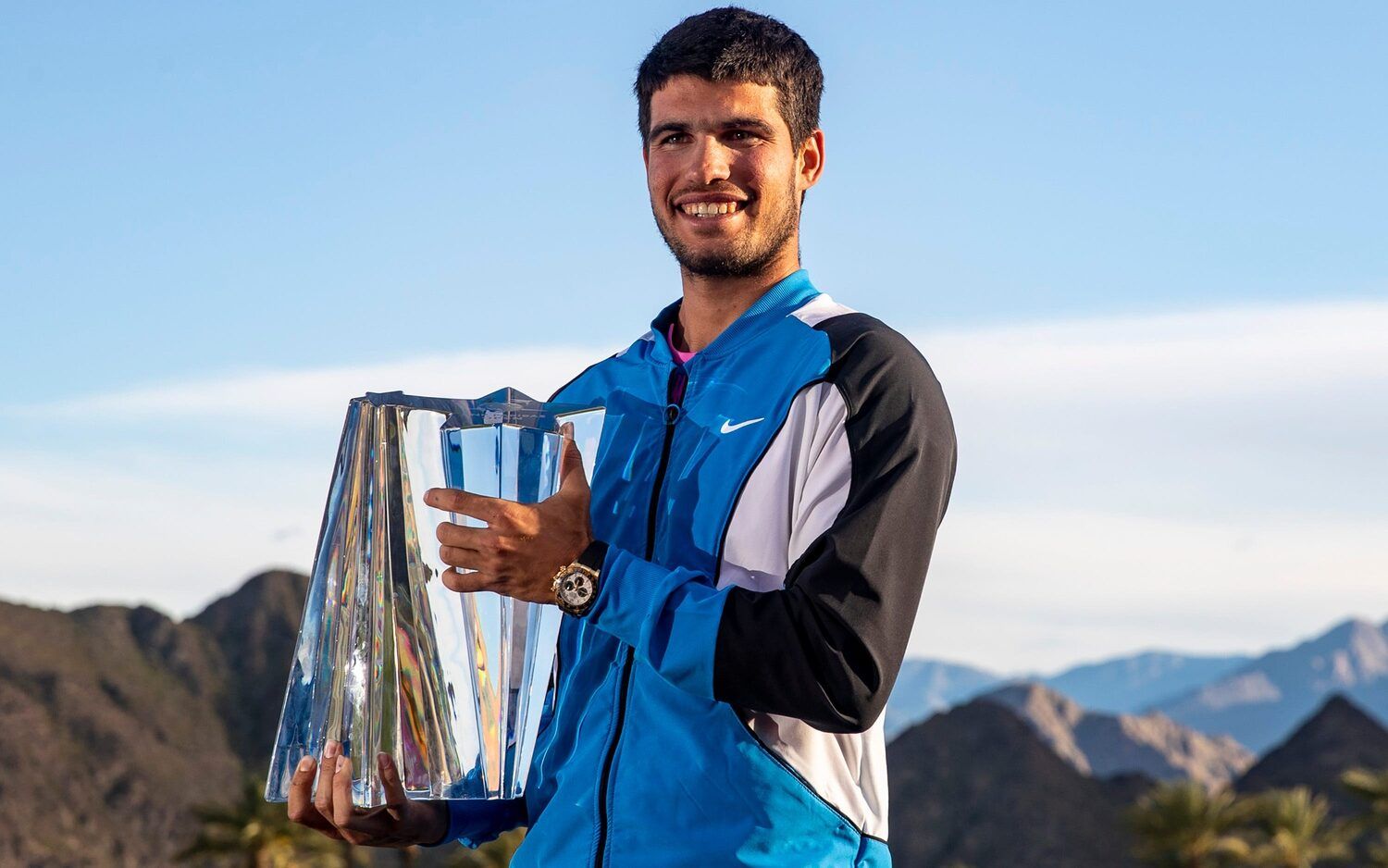 2024 BNP Paribas Open Champion Carlos Alcaraz poses for a photo with his trophy on a deck at Stadium 1 with the Santa Rosa mountains in the background in Indian Wells, Calif., Sunday, March 17, 2024.