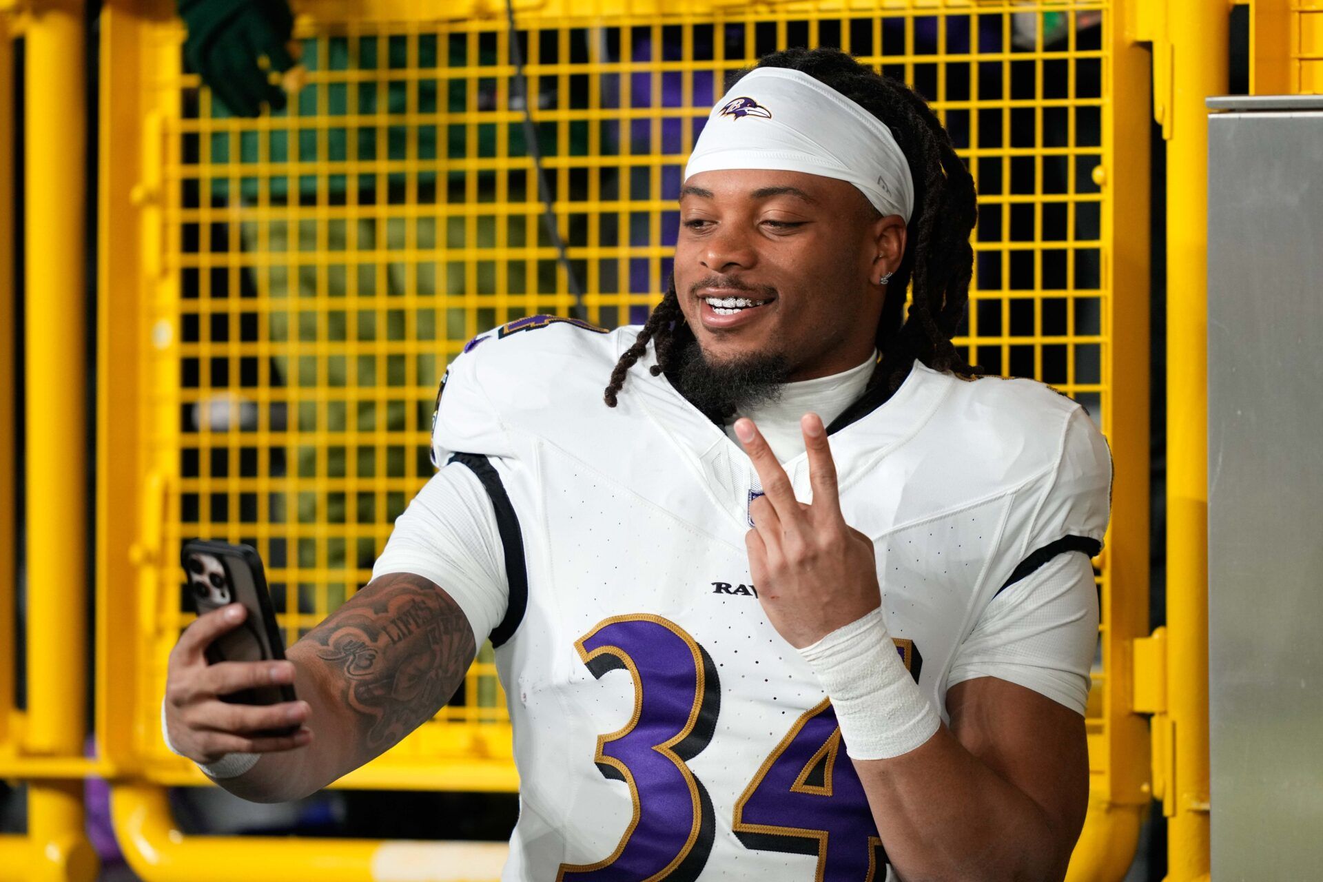 Baltimore Ravens running back Keaton Mitchell (34) takes a selfie  before a game against the Green Bay Packers at Lambeau Field.