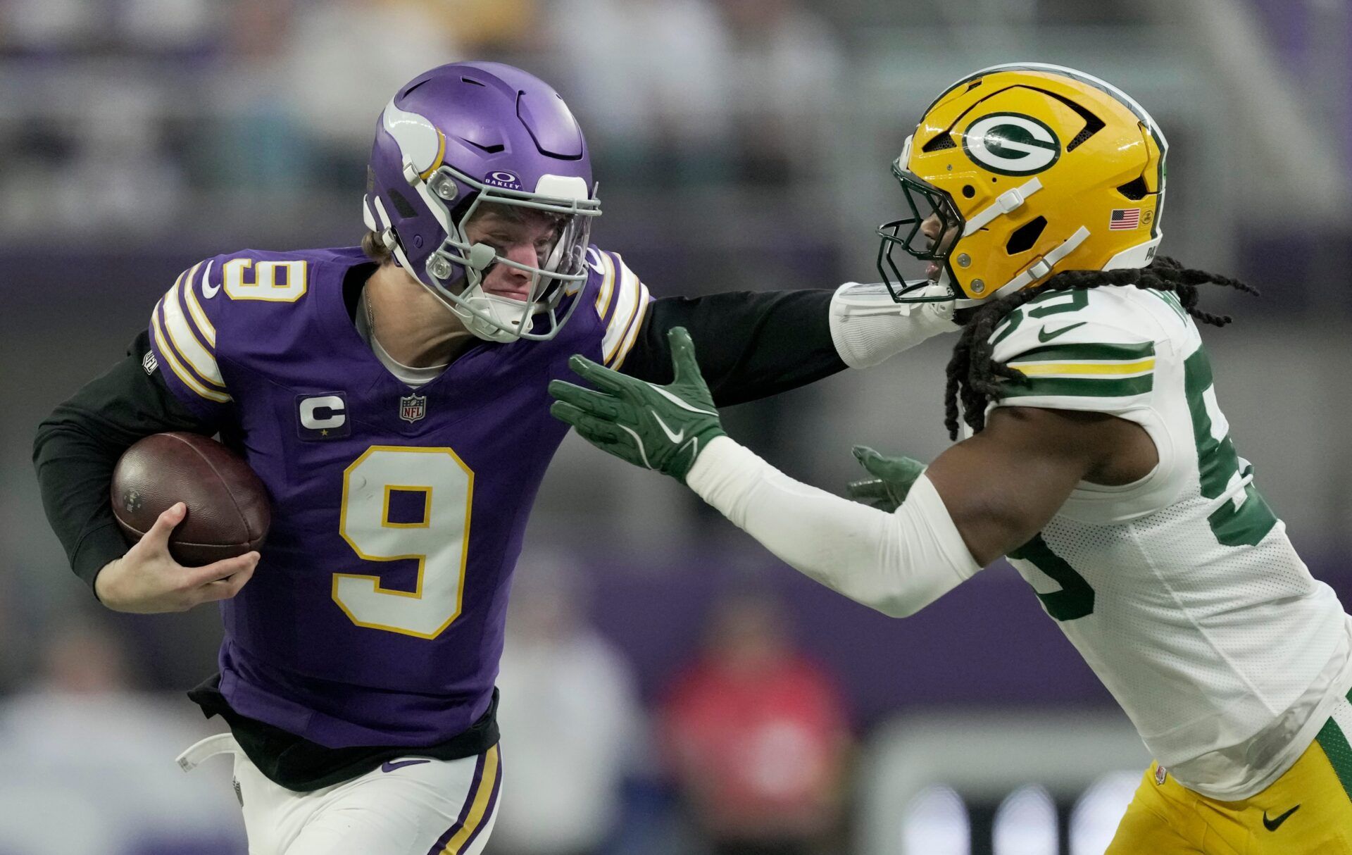 Minnesota Vikings quarterback J.J. McCarthy (9) stiff-arms Green Bay Packers linebacker Ty'Ron Hopper (59) after a seven yard run during the first quarter of their game Sunday, January 4, 2026 at U.S. Bank Stadium in Minneapolis, Minnesota.