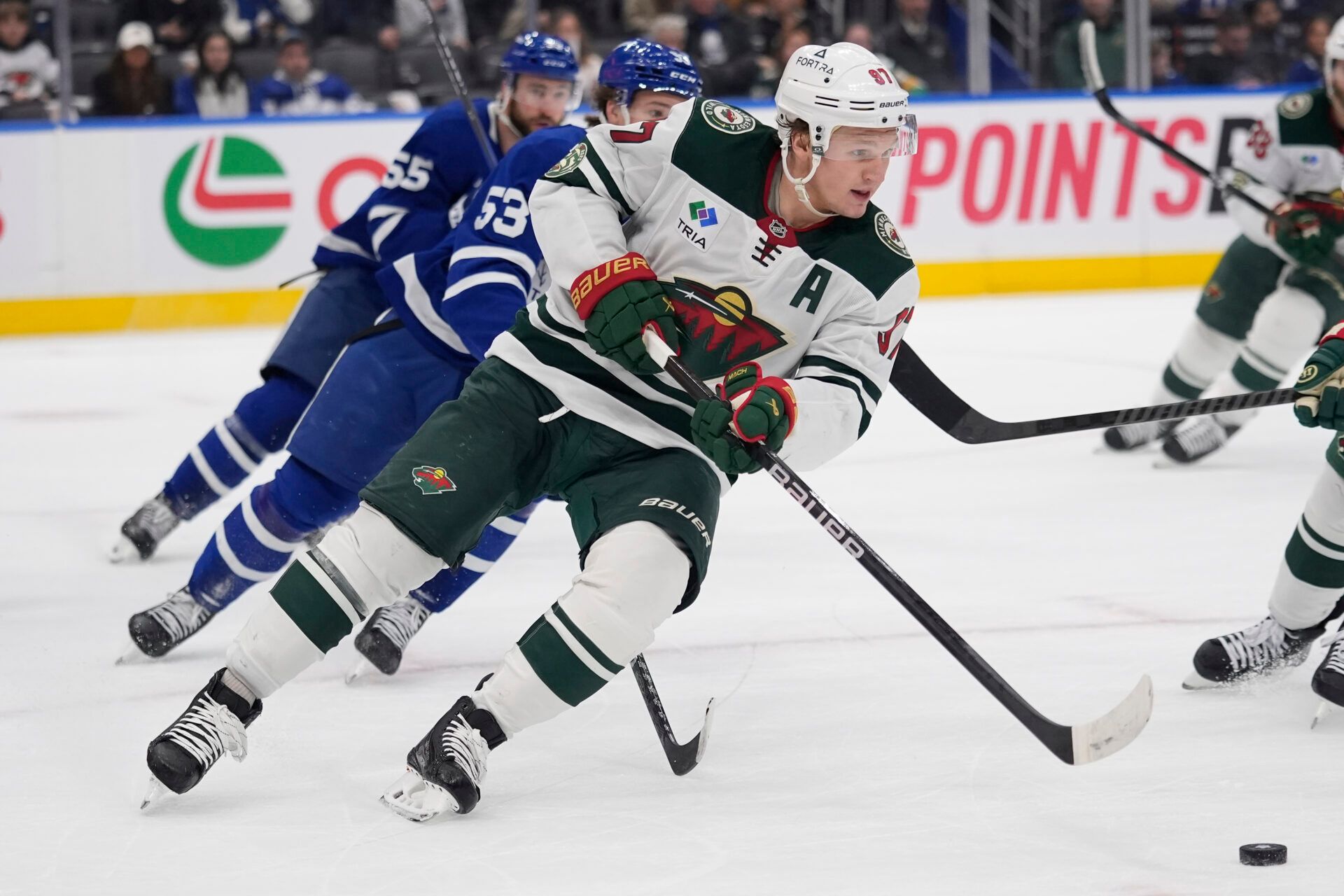 Minnesota Wild forward Kirill Kaprizov (97) plays the puck against Toronto Maple Leafs right-wing Easton Cowan (53) during the third period at Scotiabank Arena.