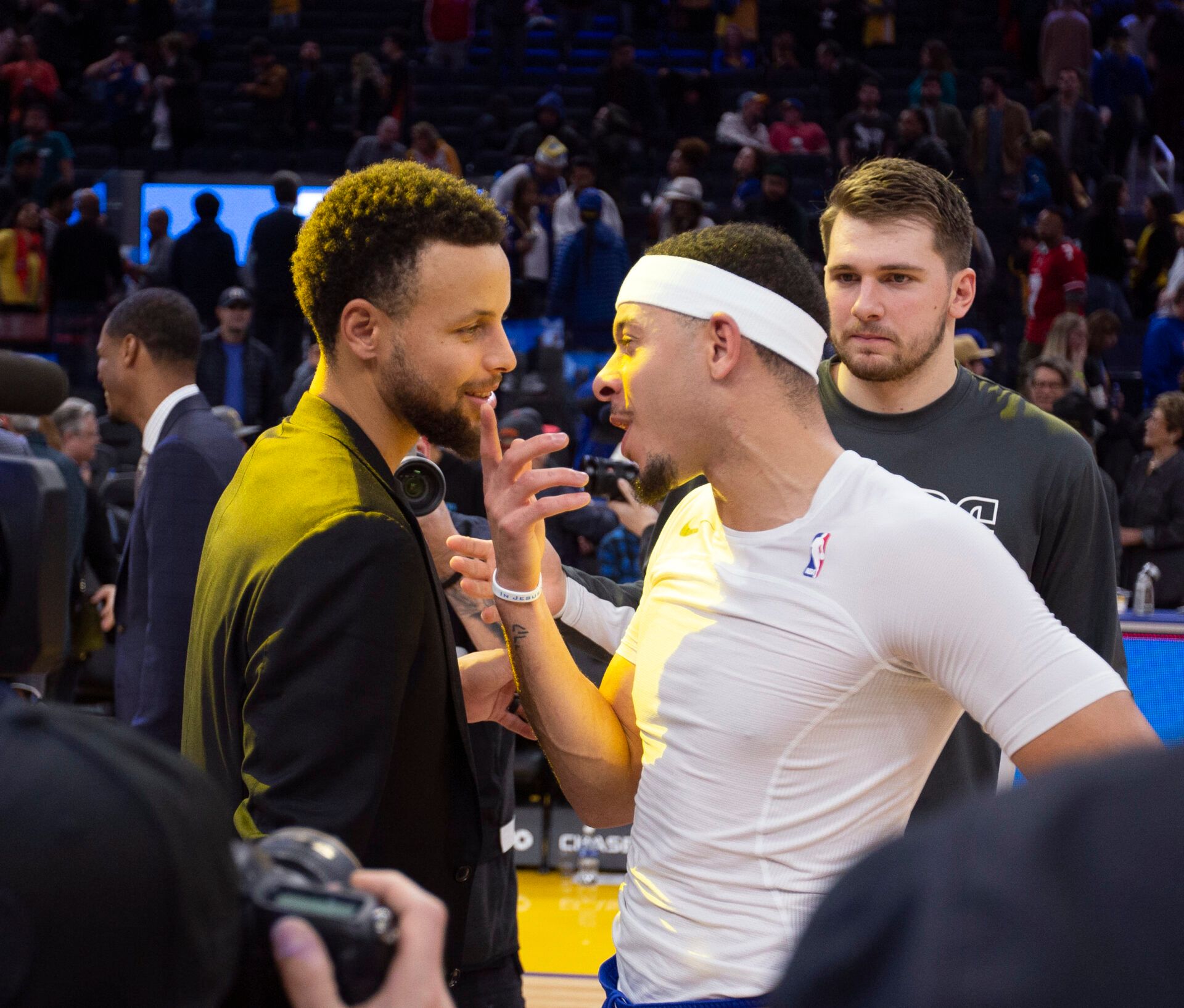 Golden State Warriors guard Stephen Curry, left, exchanges pleasantries with his brother Dallas Mavericks guards Seth Curry and Luka Doncic following their NBA basketball game at Chase Center.