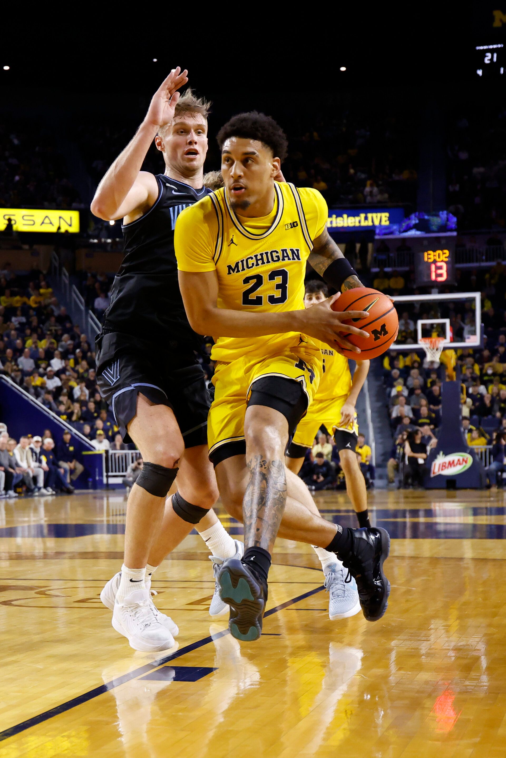Michigan Wolverines forward Yaxel Lendeborg (23) dribbles defended by Villanova Wildcats forward Duke Brennan (24) in the first half at Crisler Center.