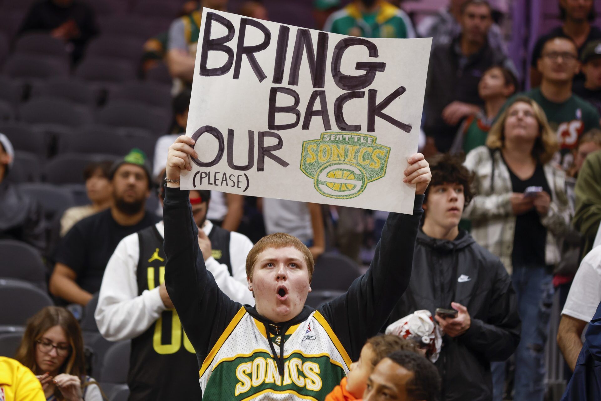 A Seattle Supersonics fan holds a sign advocating for their return during pregame warmups between the LA Clippers and Utah Jazz at Climate Pledge Arena.